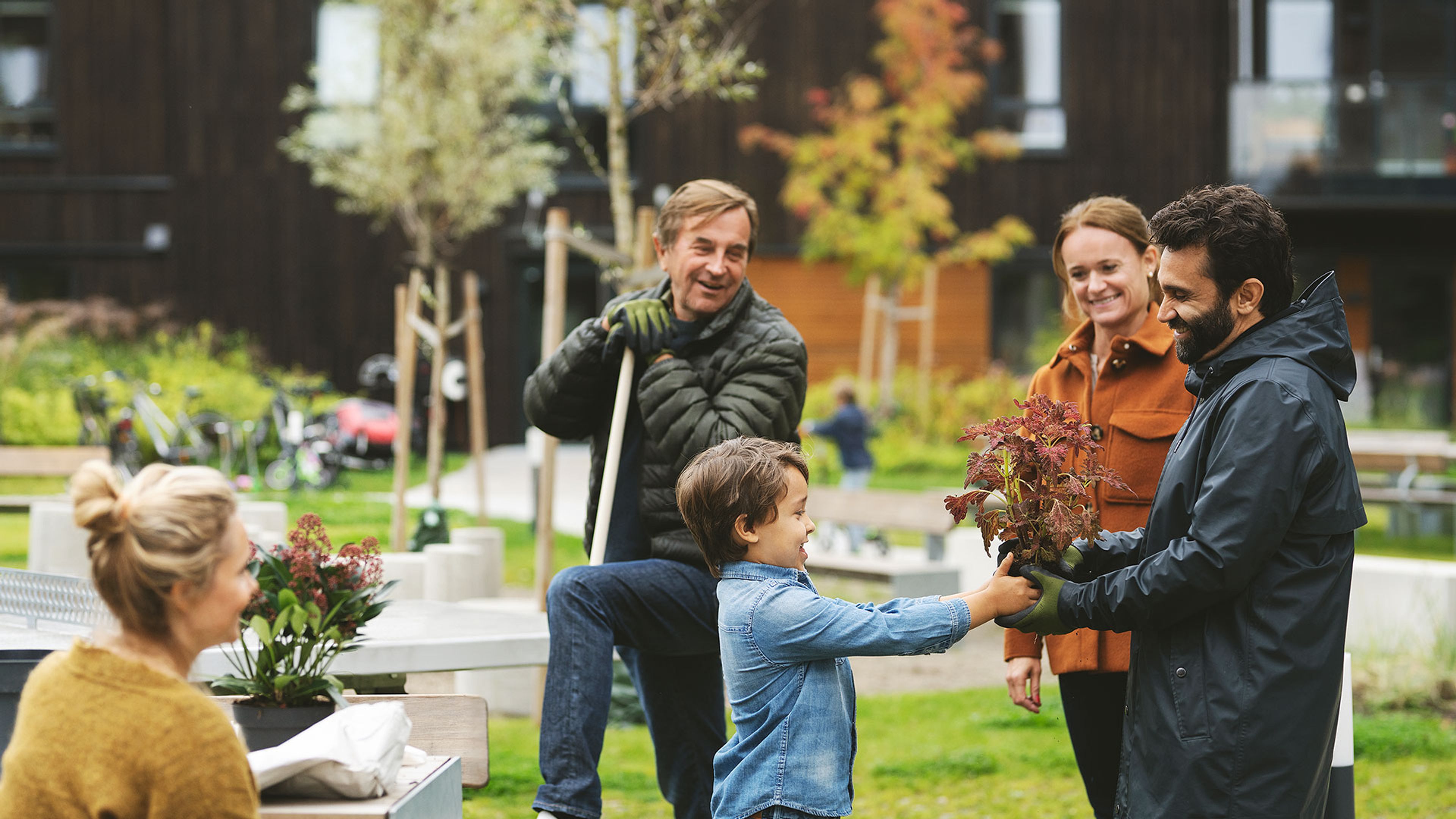 familj som är ute i trädgården och fixar tillsammans