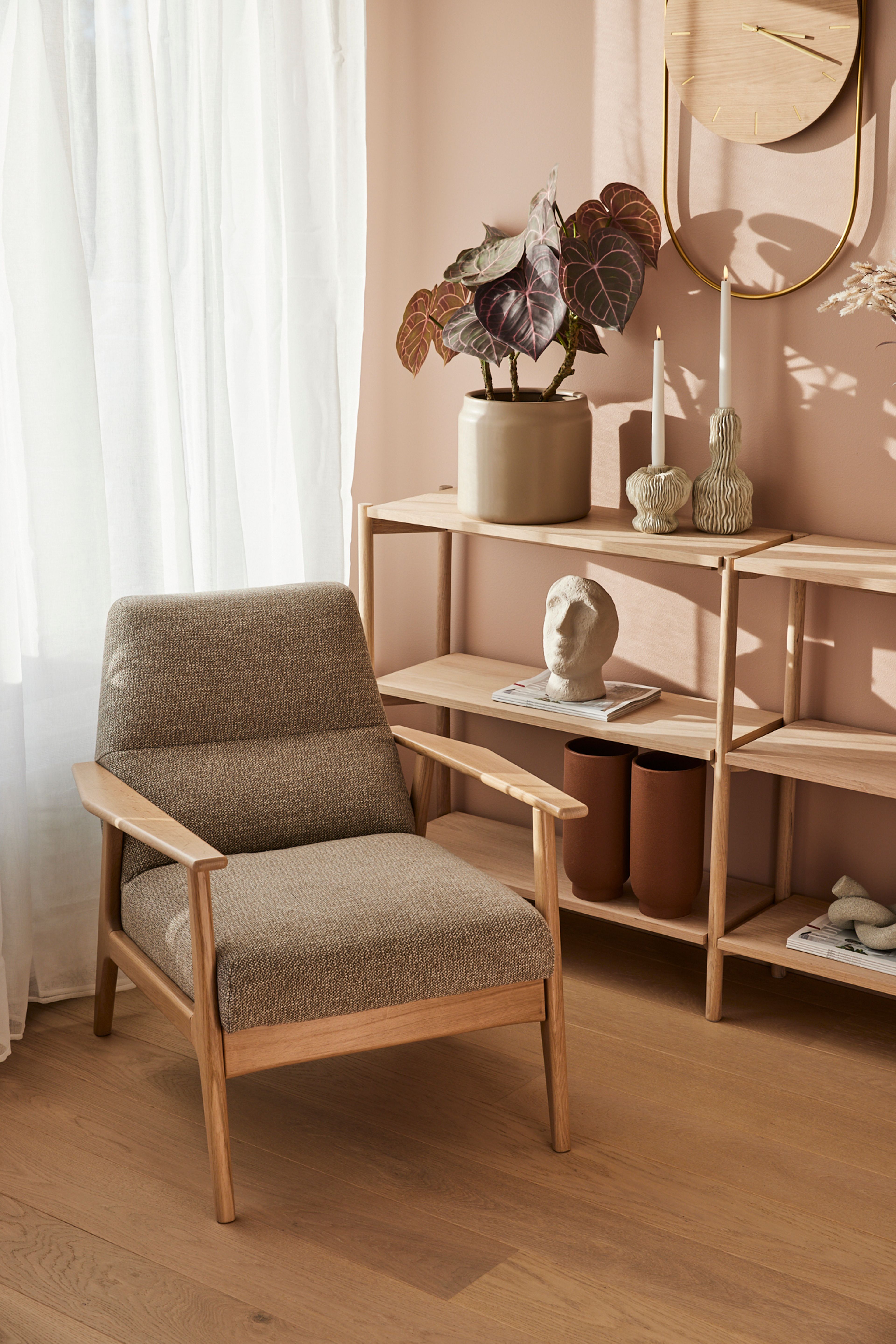 Stue på Vollebekk med stol og hyller med interiørdetaljer.