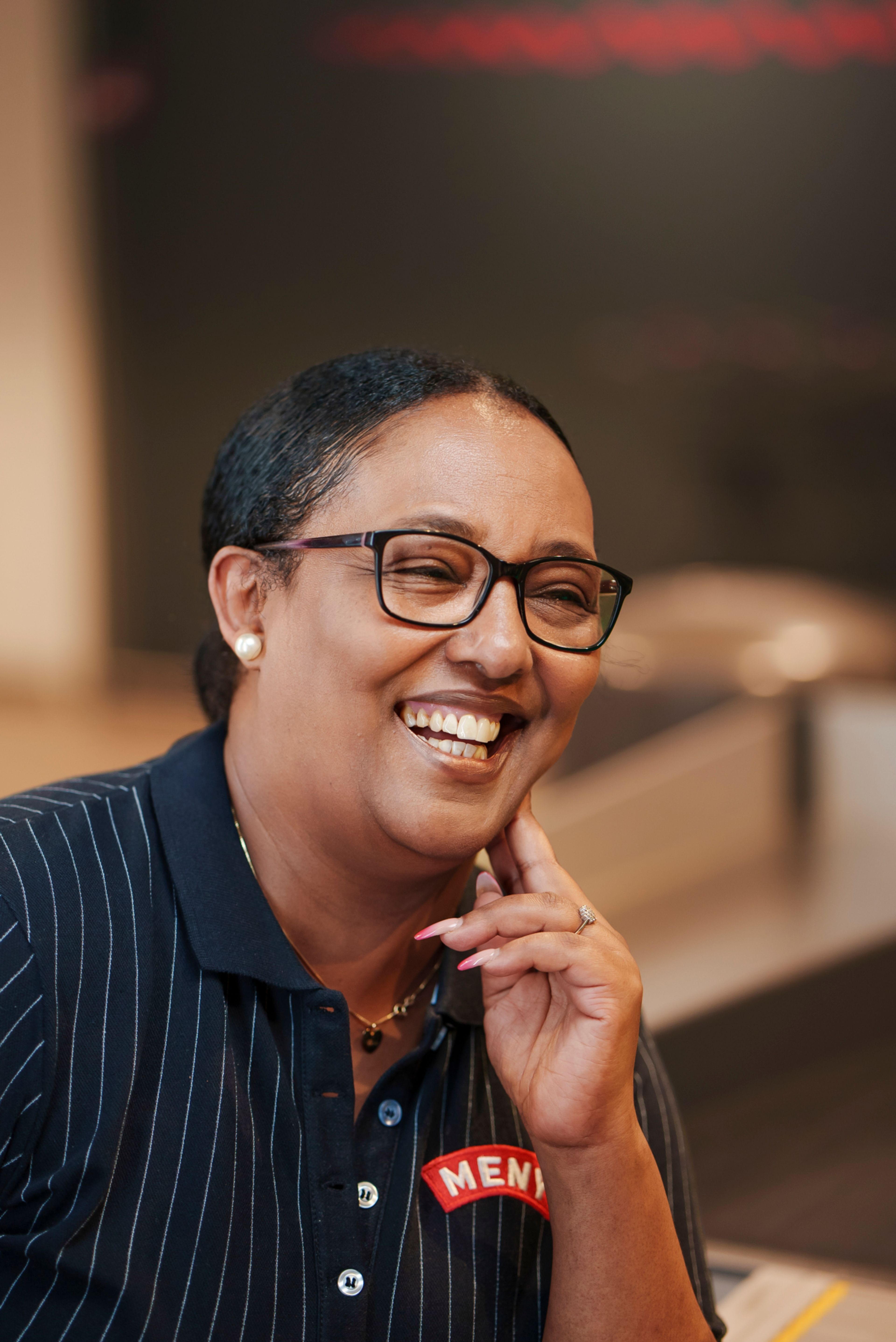 Senait sitter ved kassa på Meny på Tveita Senter.