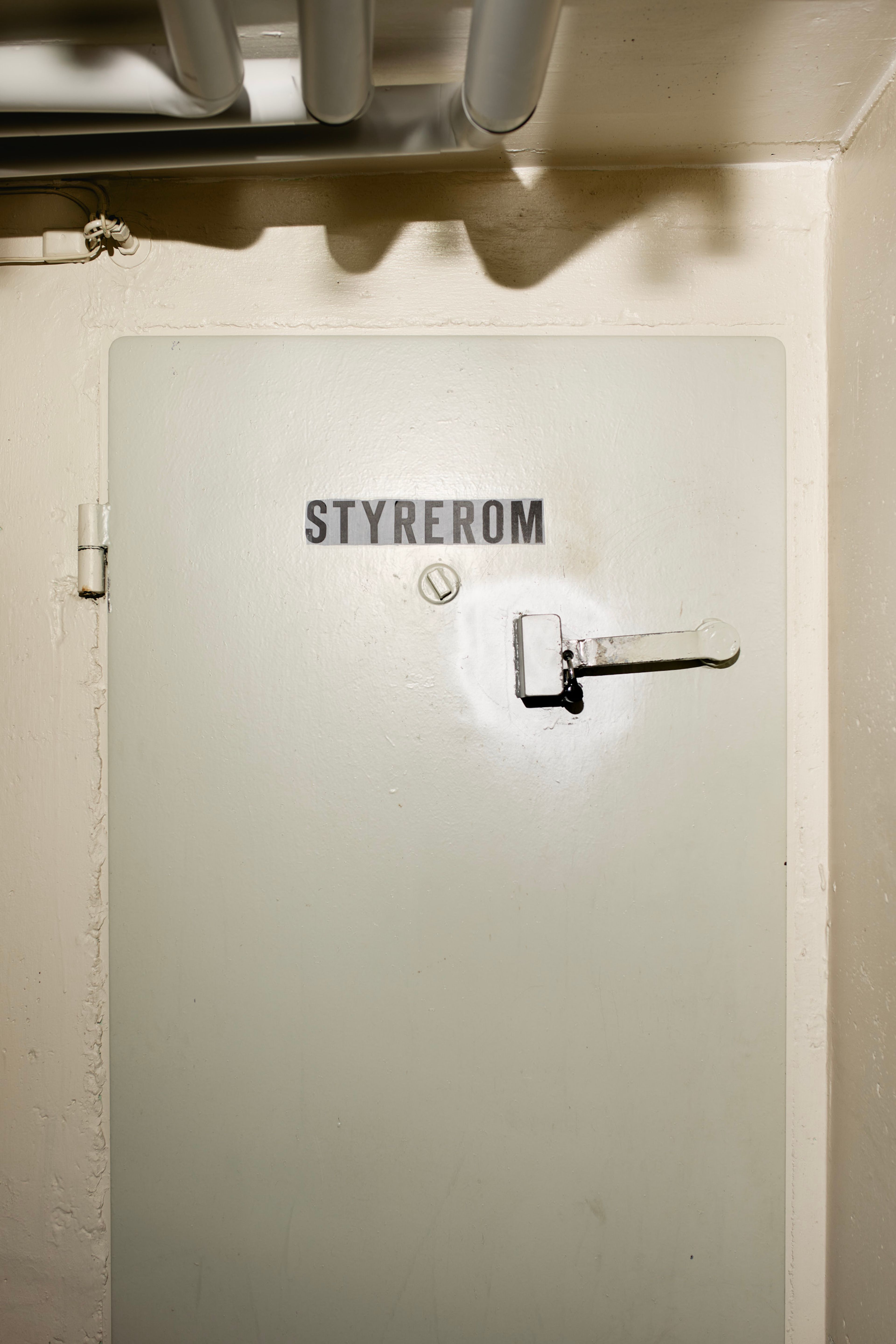 Foto av døra inn til bomberommet i en av blokkene i Rognerud borettslag. Dette bomberommet brukes som styrerom.