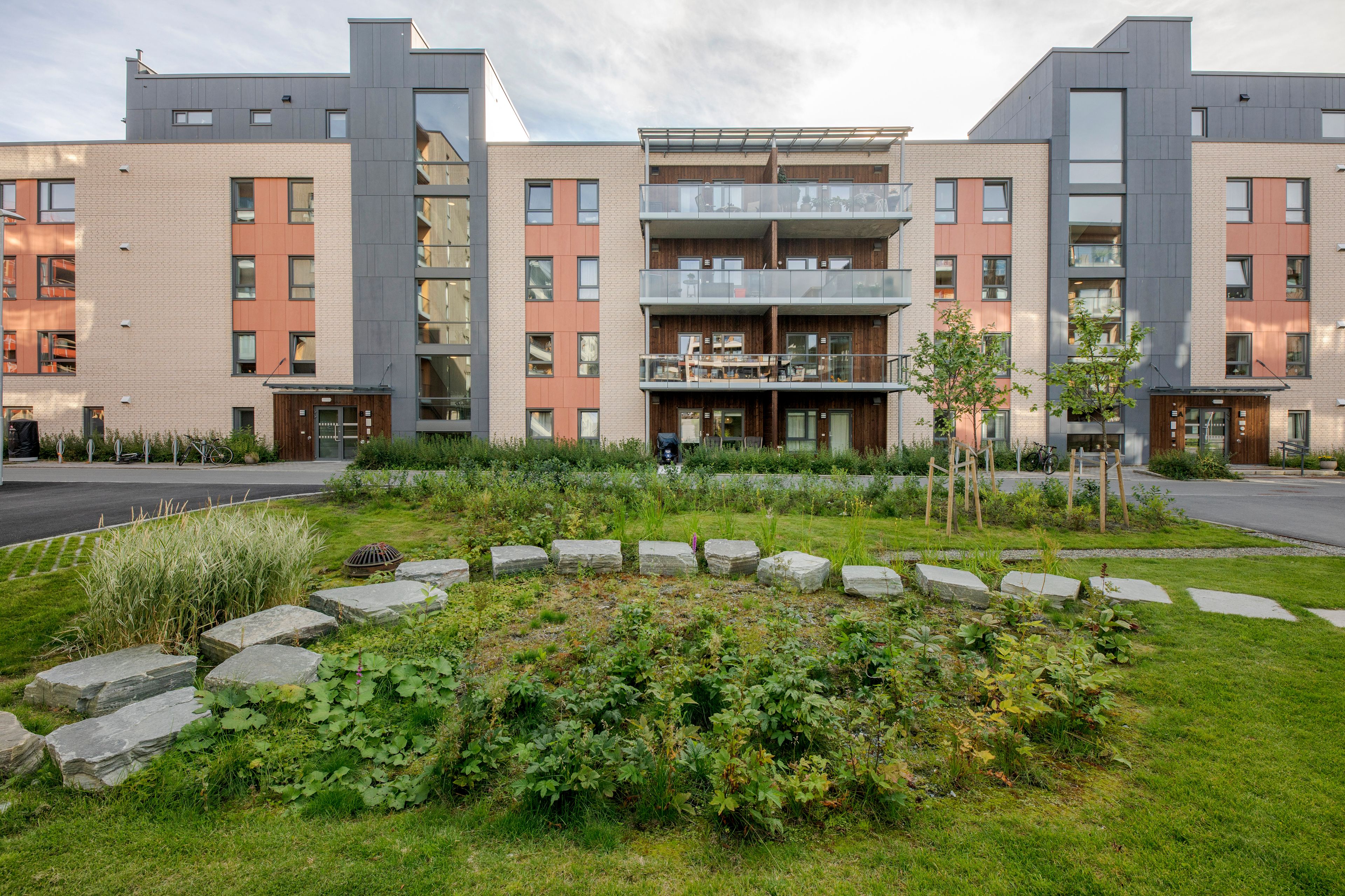Foto av fasaden til byggene i Ladebyhagen med grønt område foran.