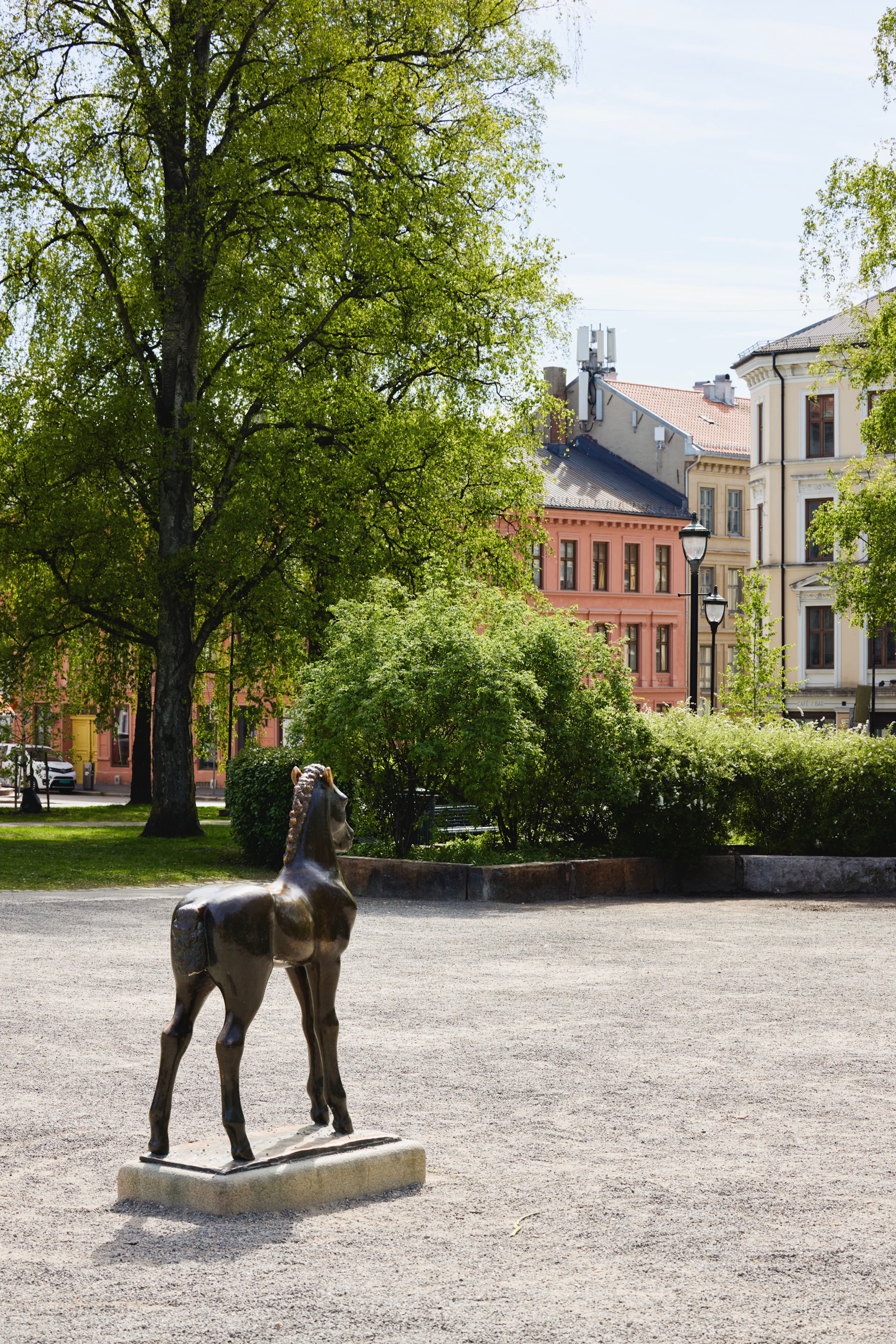 Statue av en hest i en park en sommerdag.