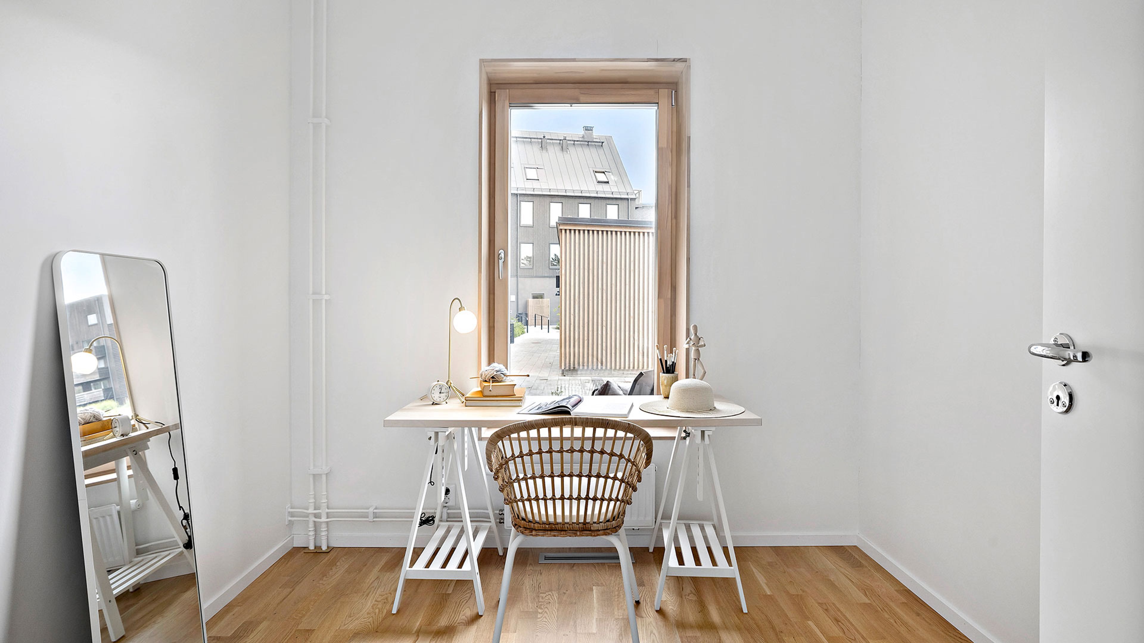 Interiör bild på gästrum med skrivbord och stol i rotting