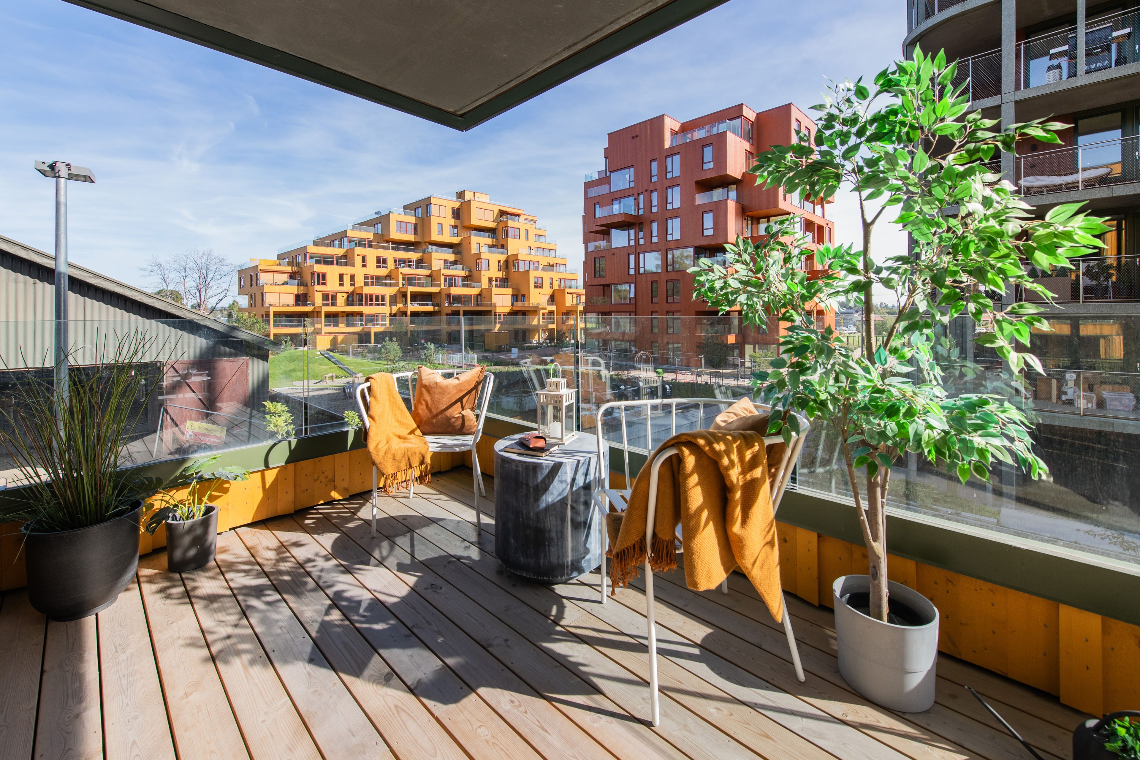 En møblert balkong i Magasinparken med utsikt til den flotte arkitekturen i området.
