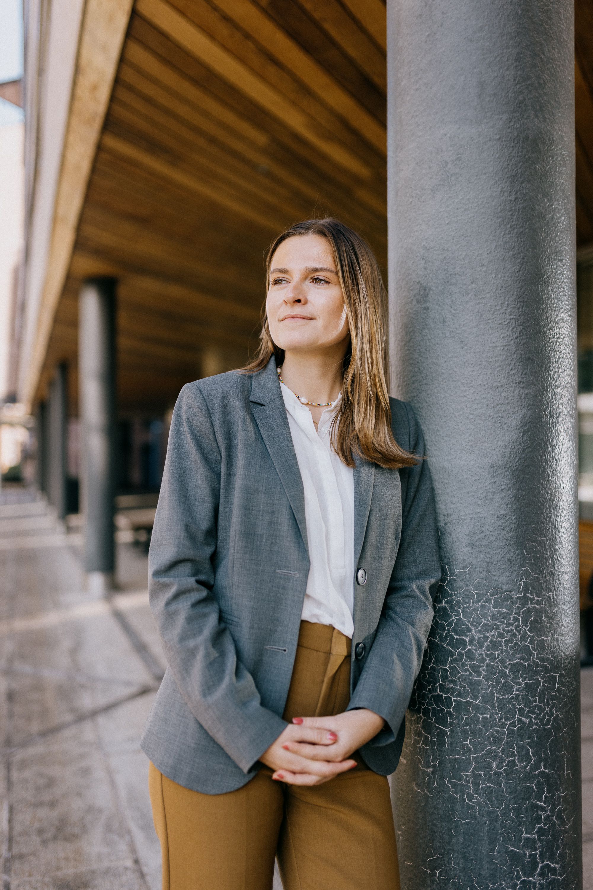 Marte Herje Strømme lener seg på en søyle ute.