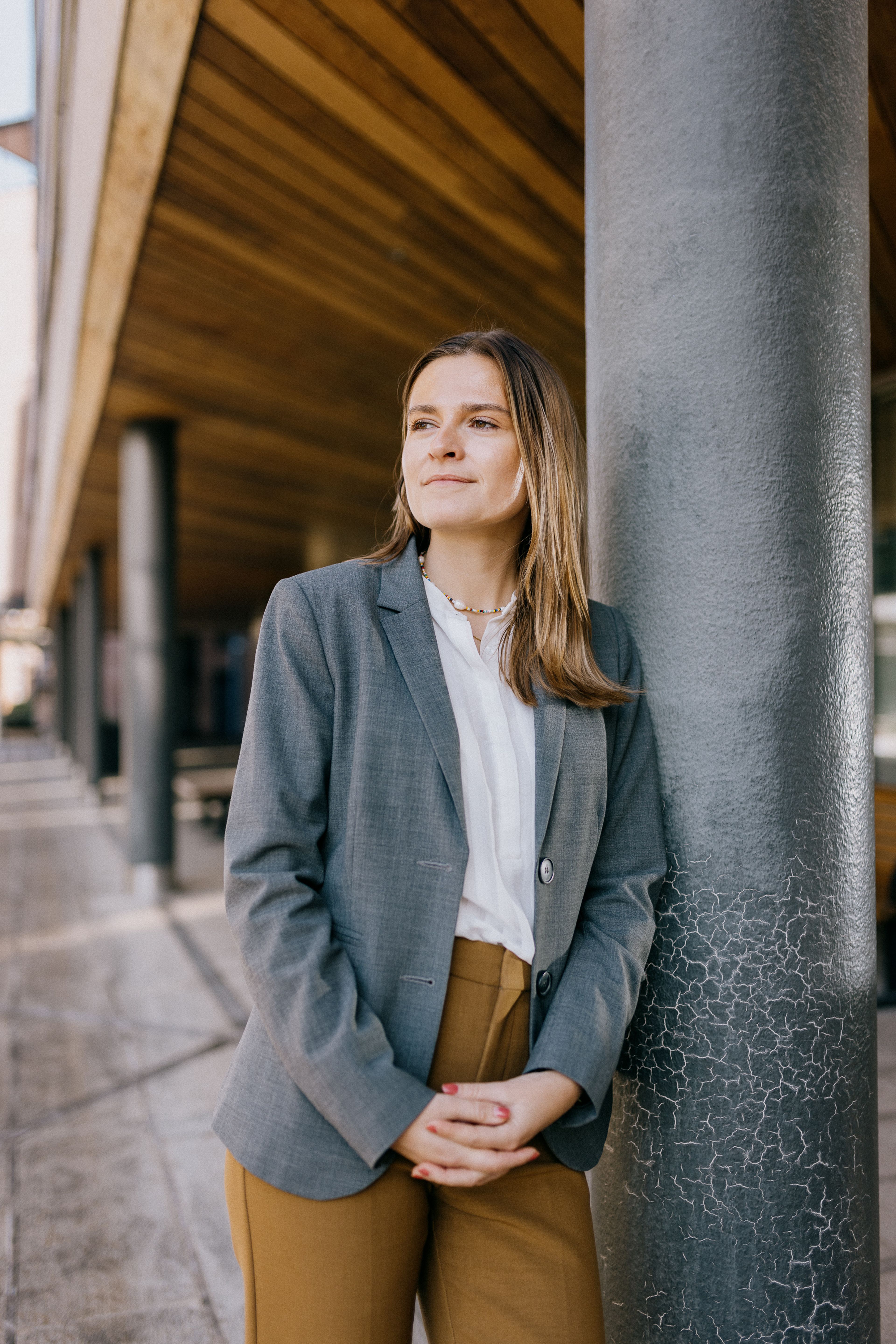 Marte Herje Strømme lener seg på en søyle ute.