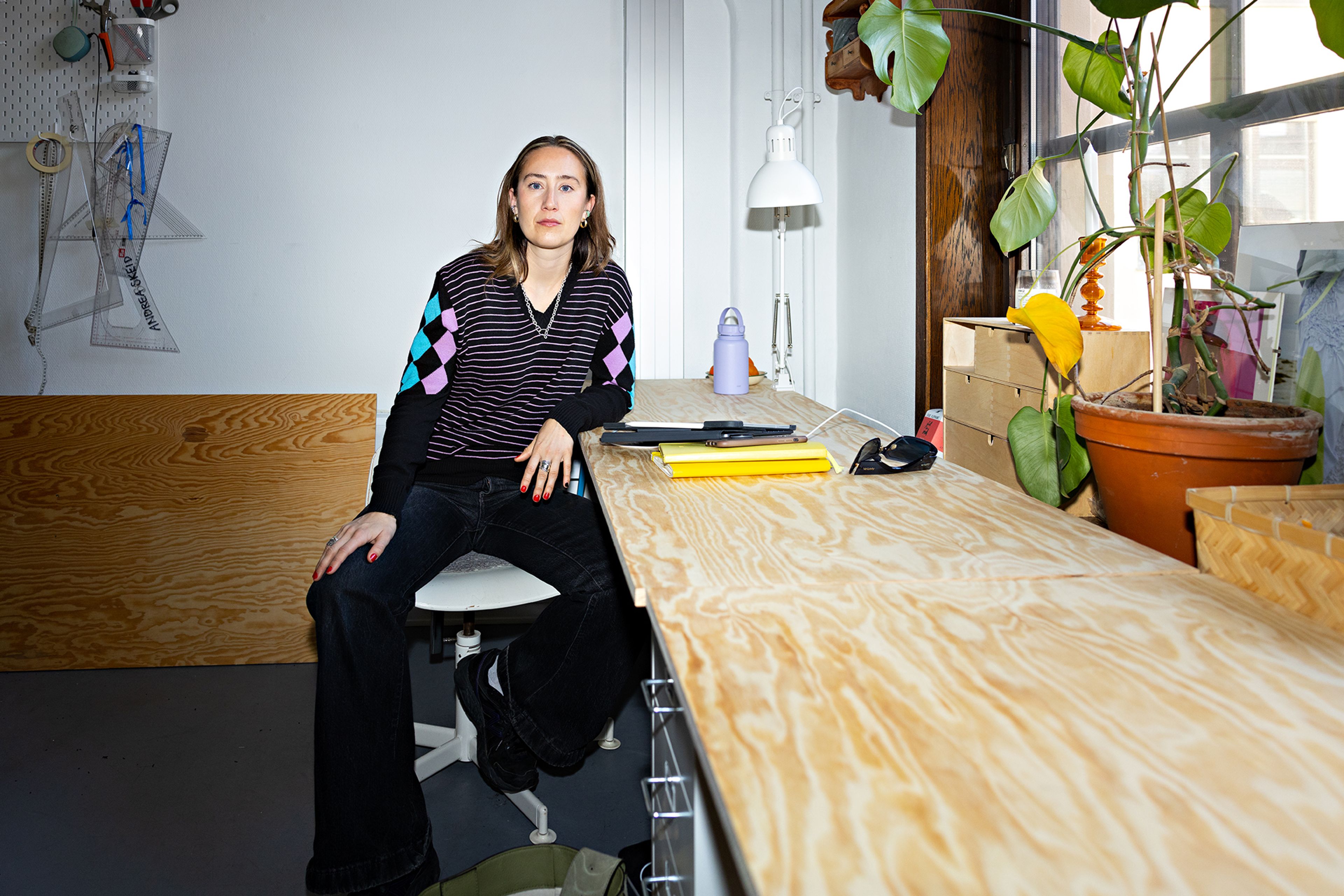 Foto av Alva Brosten som sitter ved arbeidsbenken sin.