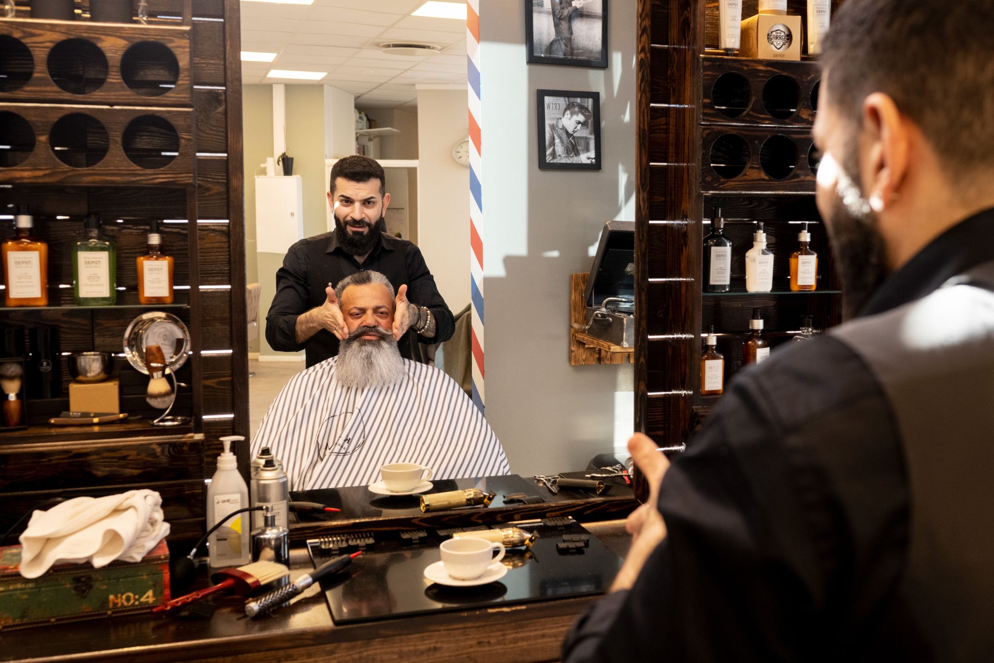 Karam klipper kunde i egen frisørsalong.