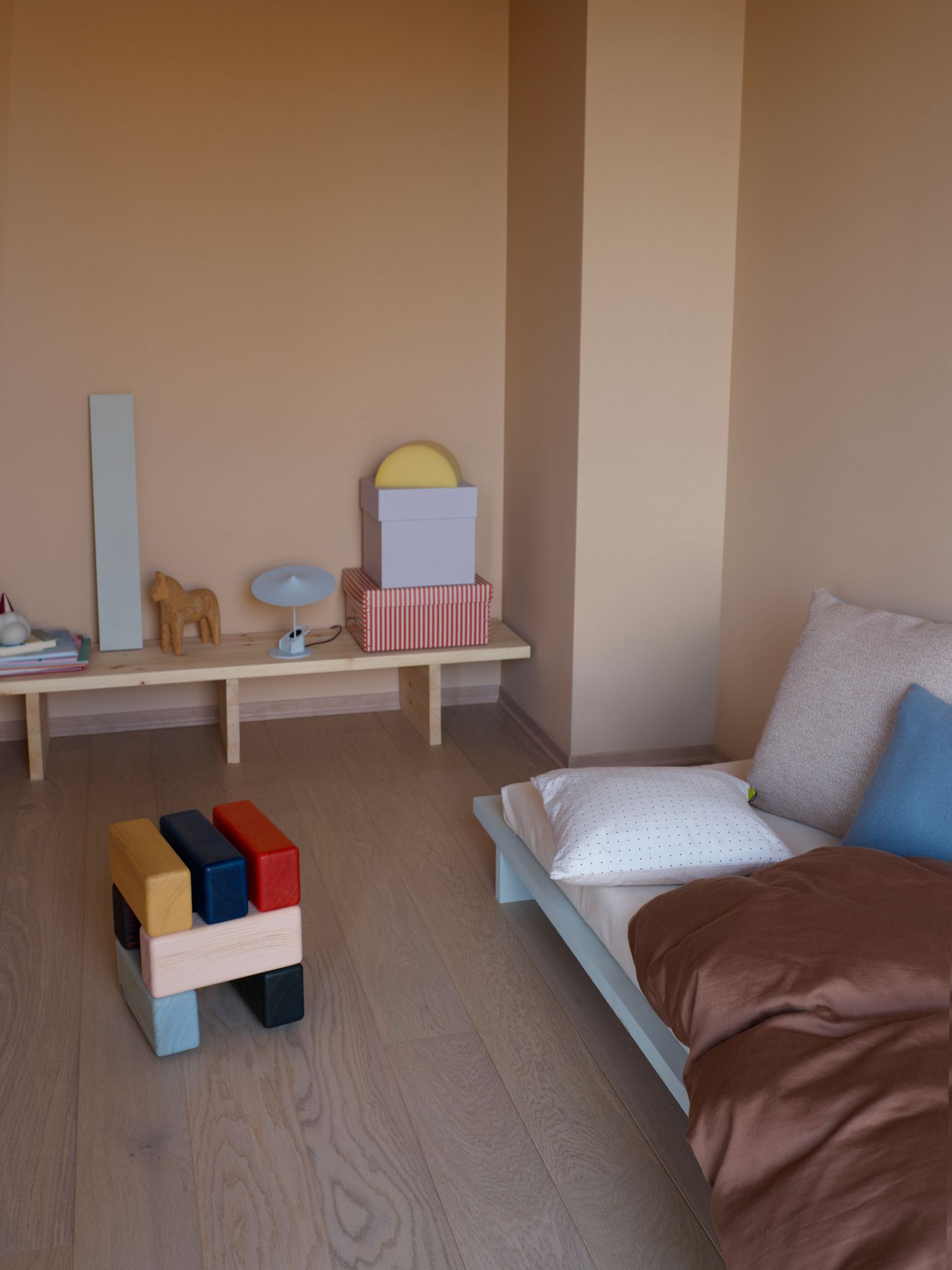 Barnesoverom med selvbygd seng, krakk fra Are Mokkelbost og lav benk med pyntegjenstander