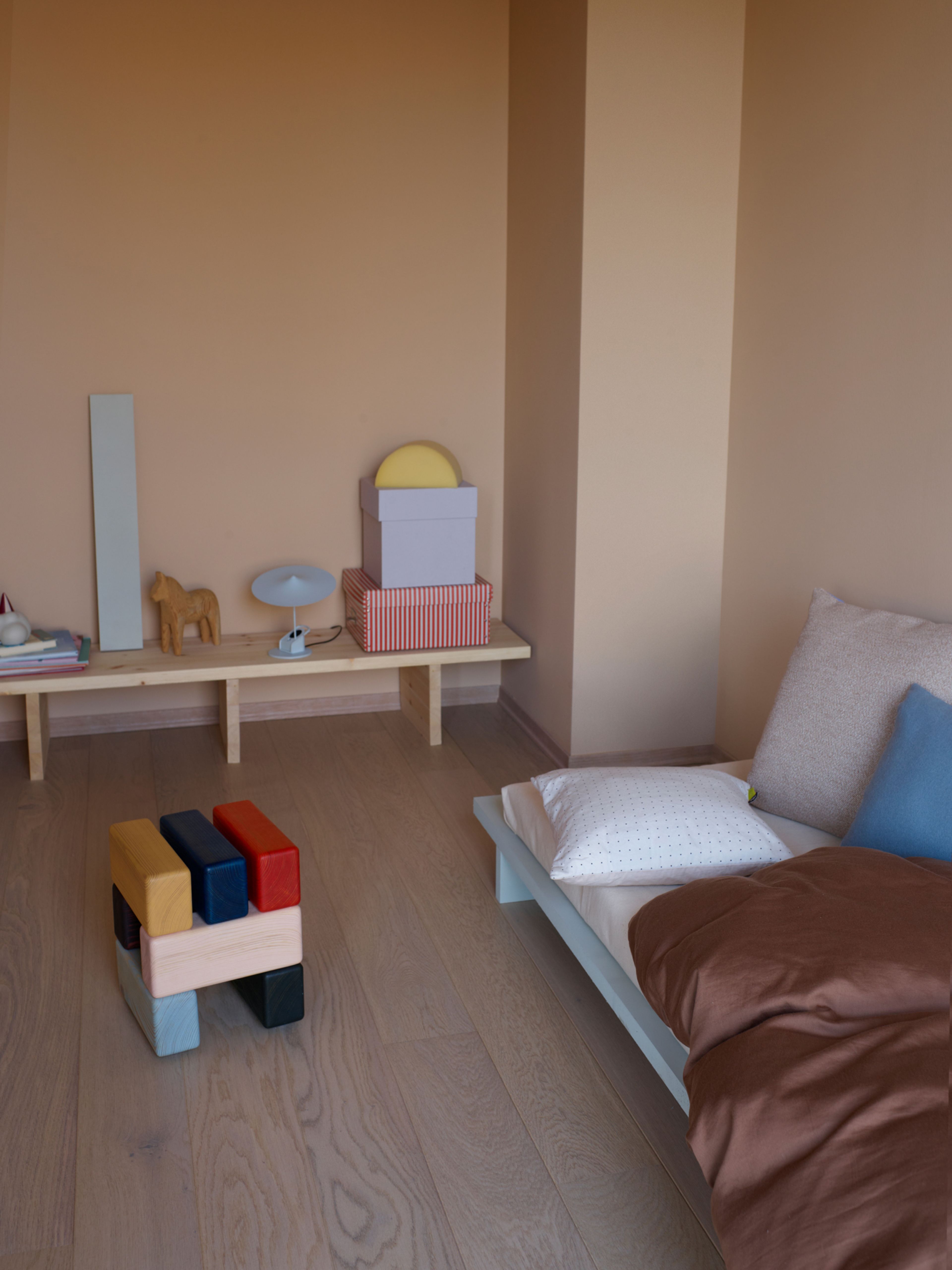 Barnesoverom med selvbygd seng, krakk fra Are Mokkelbost og lav benk med pyntegjenstander