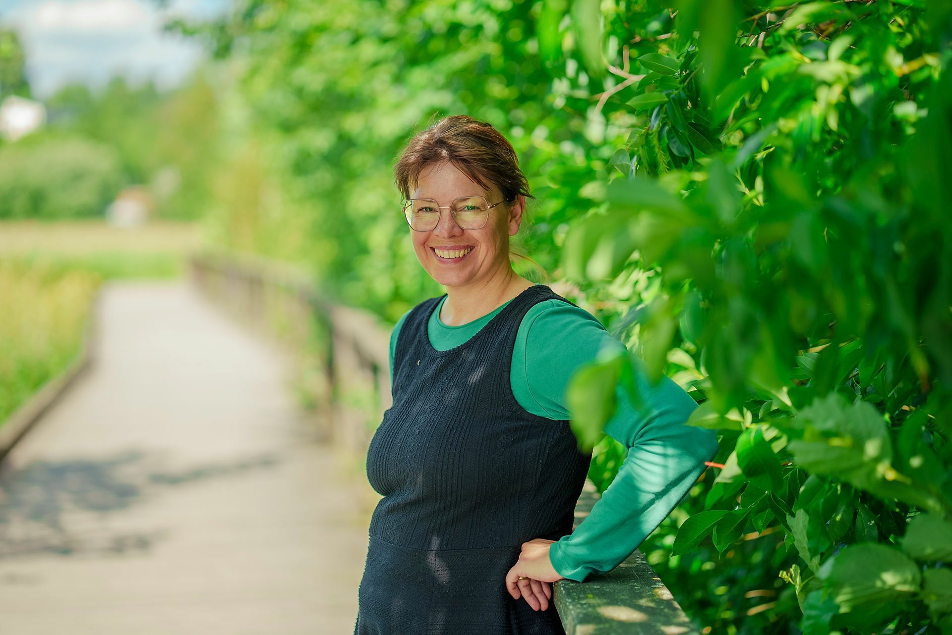 Hanne Løvbrøtte står foran grønn hekk