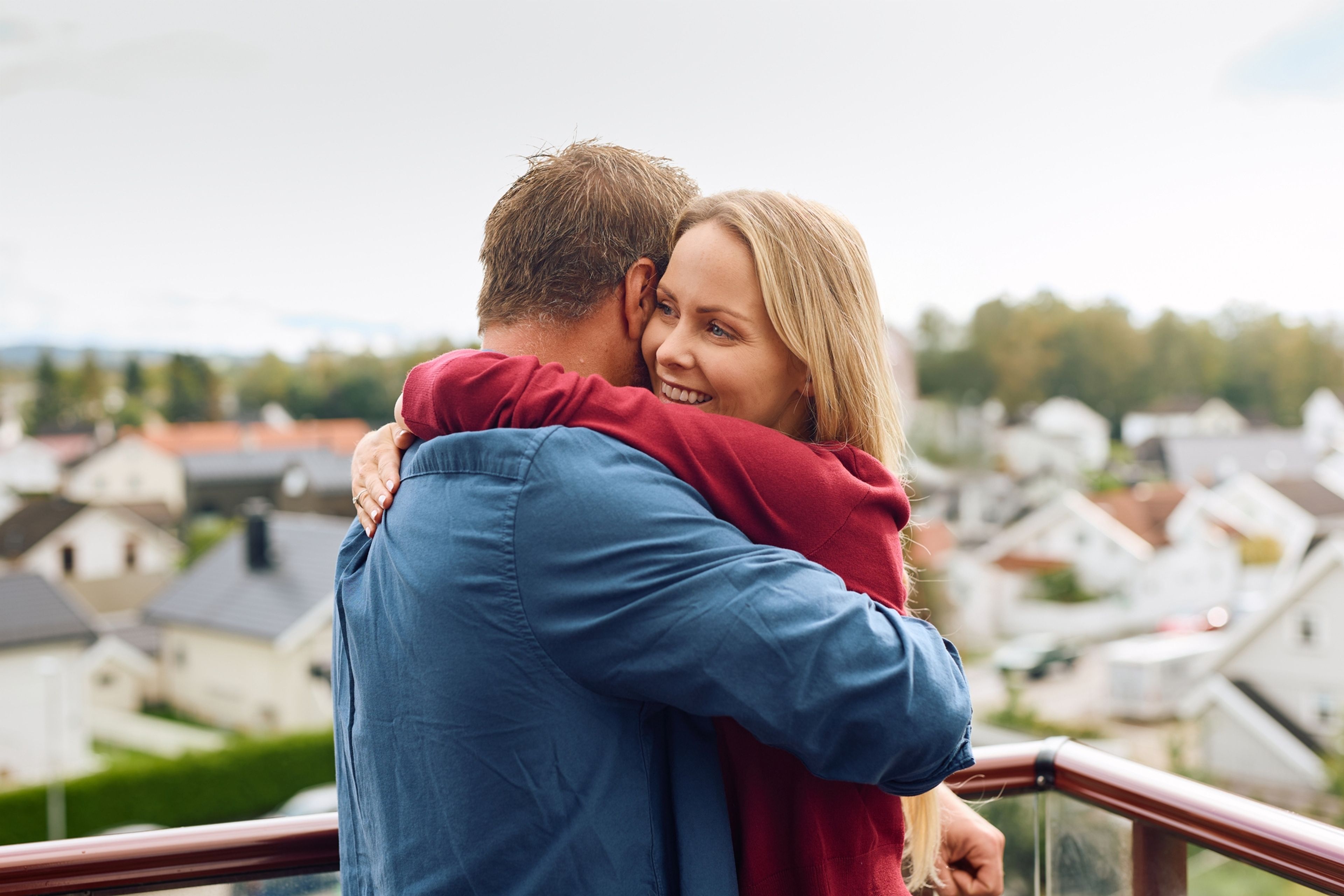 Foto av par som klemmer på en balkong
