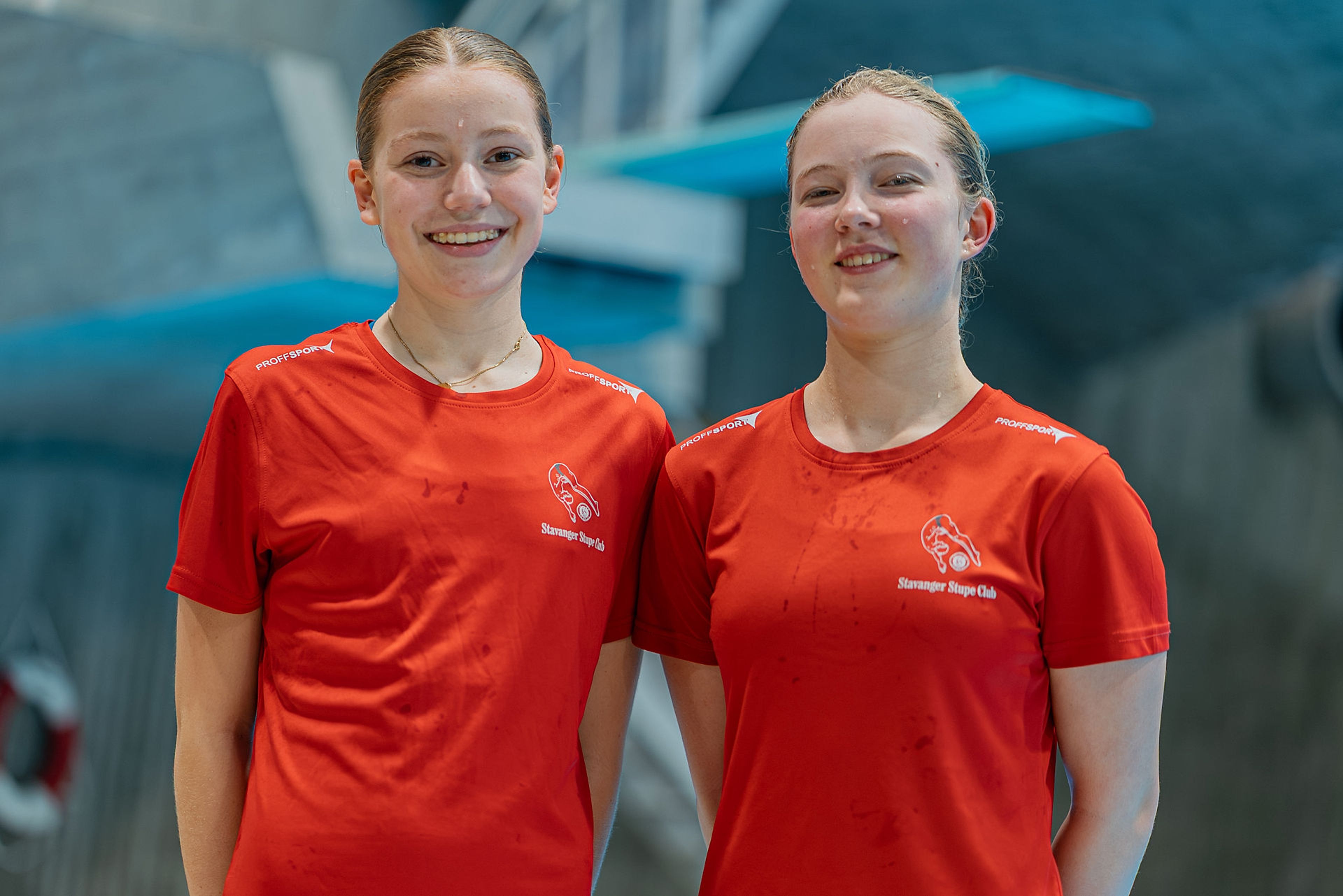 To jenter fra stupeklubben står sammen med matchende røde t-skjorter.