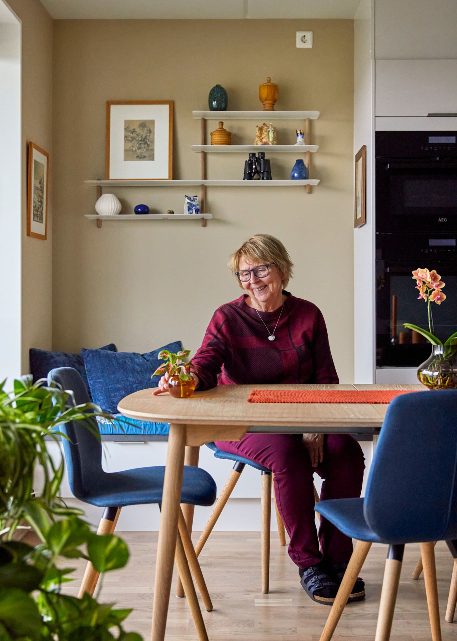 Marit Helene sitter på en stol på et kjøkken