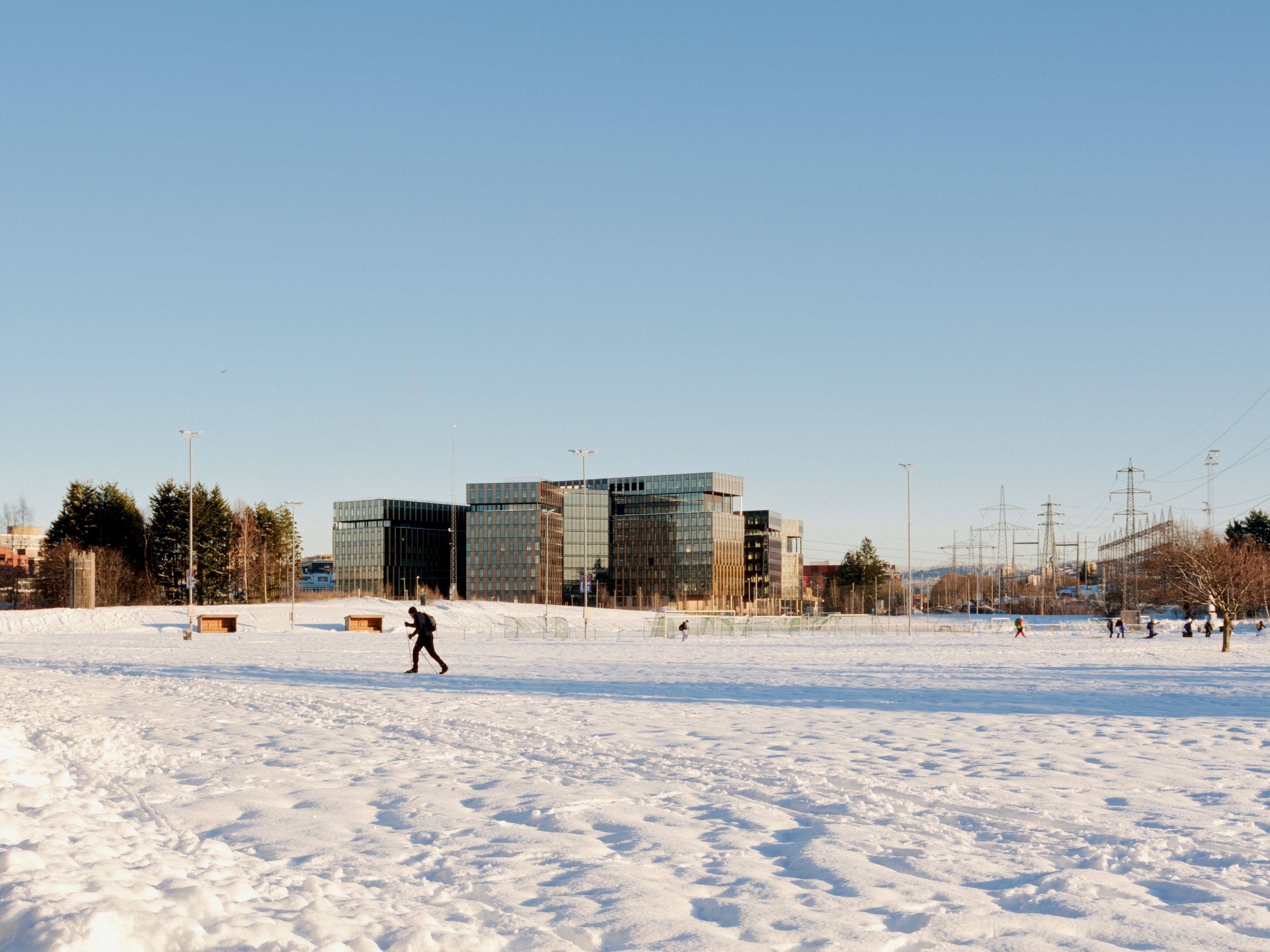 Bilde av en mann som går på ski med Construction City i bakgrunnen