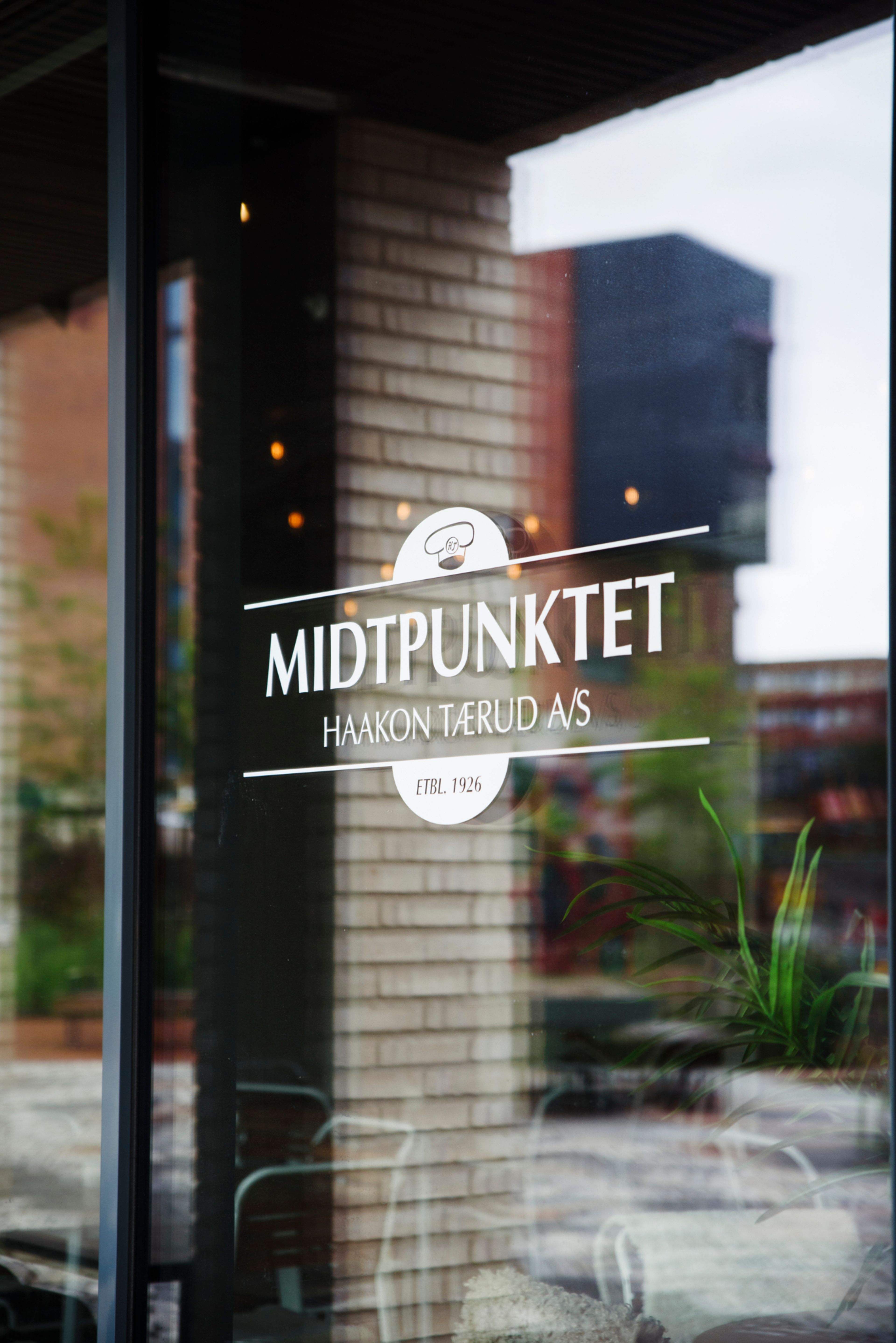 Logoen til restauranten Midtpunktet på et vindu