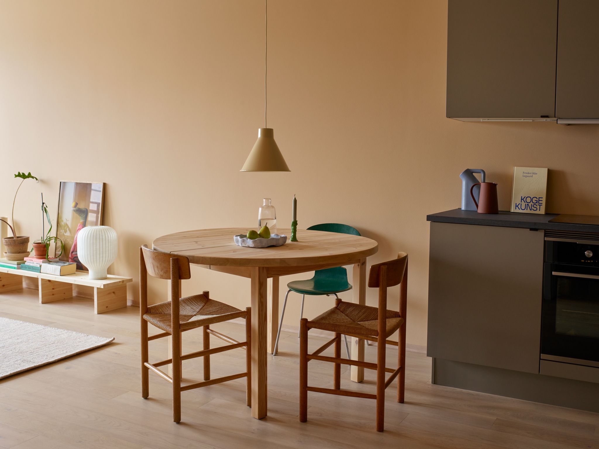 Brunt kjøkken med ferskenfargede vegger og spisestue i tre