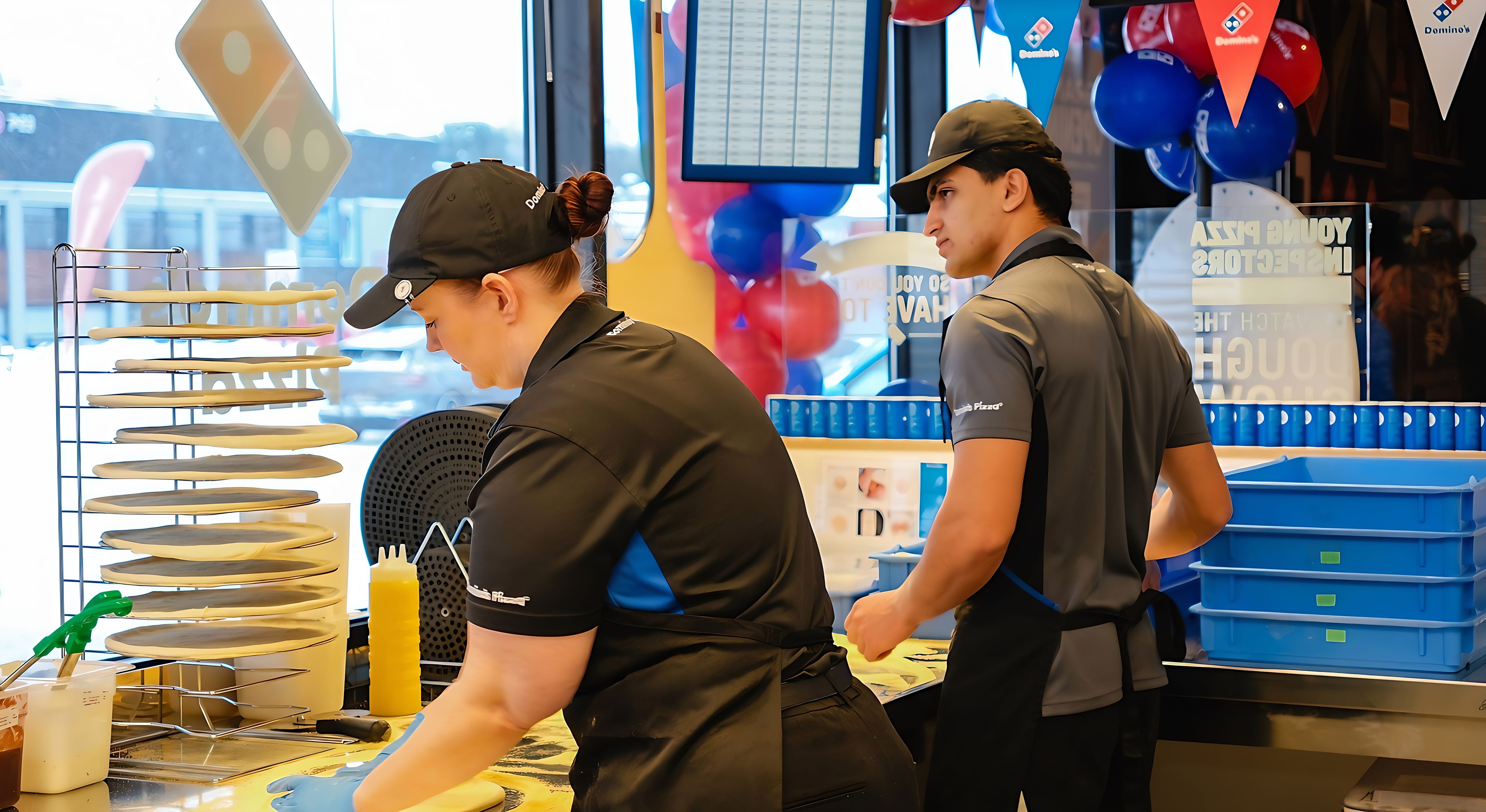 To personer baker og strekker pizzabunn