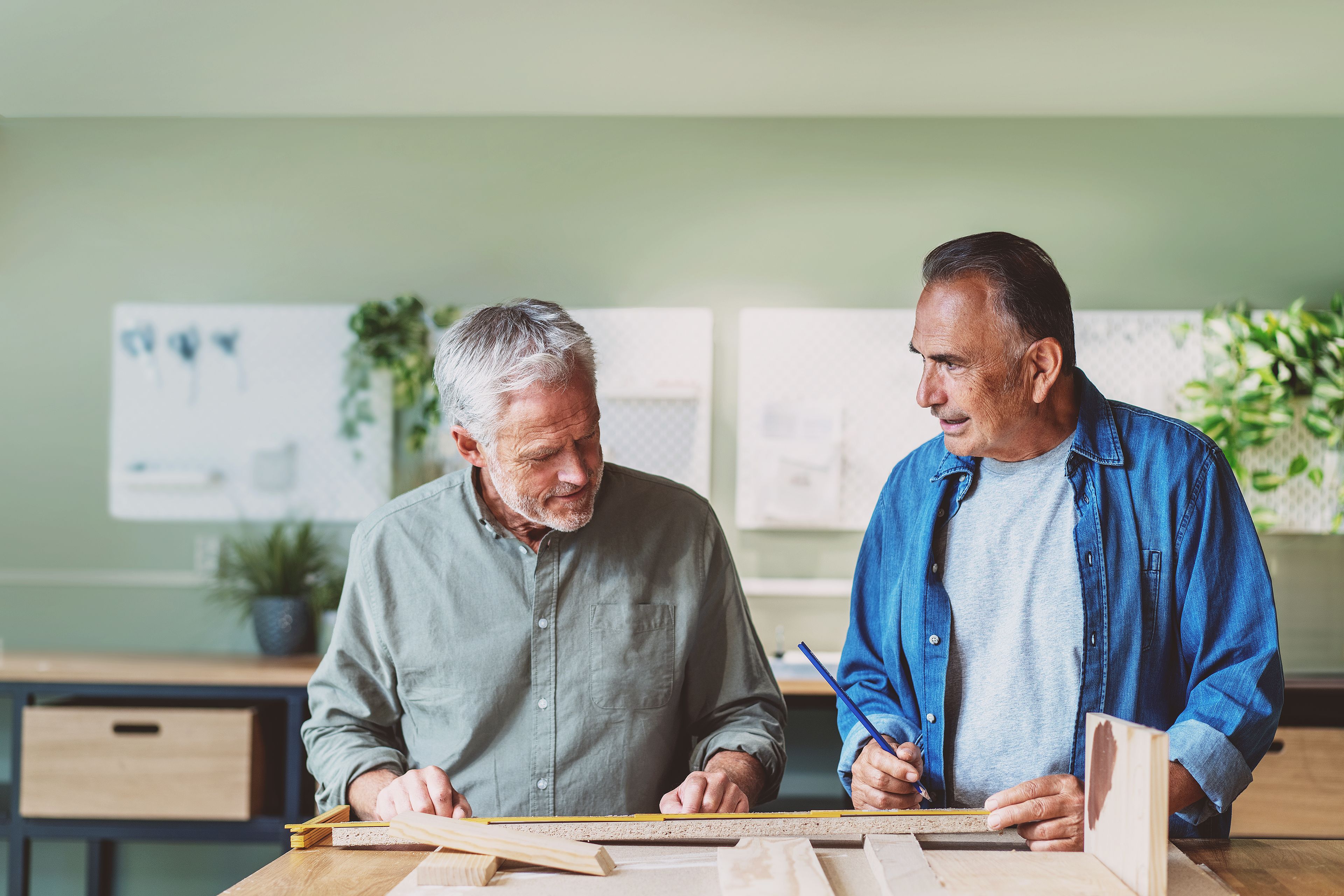 To menn måler opp og skal snekre. De ser på hverandre og funderer.