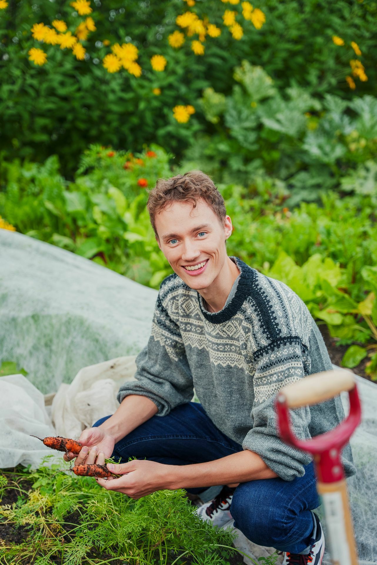 Sigurd sitter i beddet og smiler til kamera