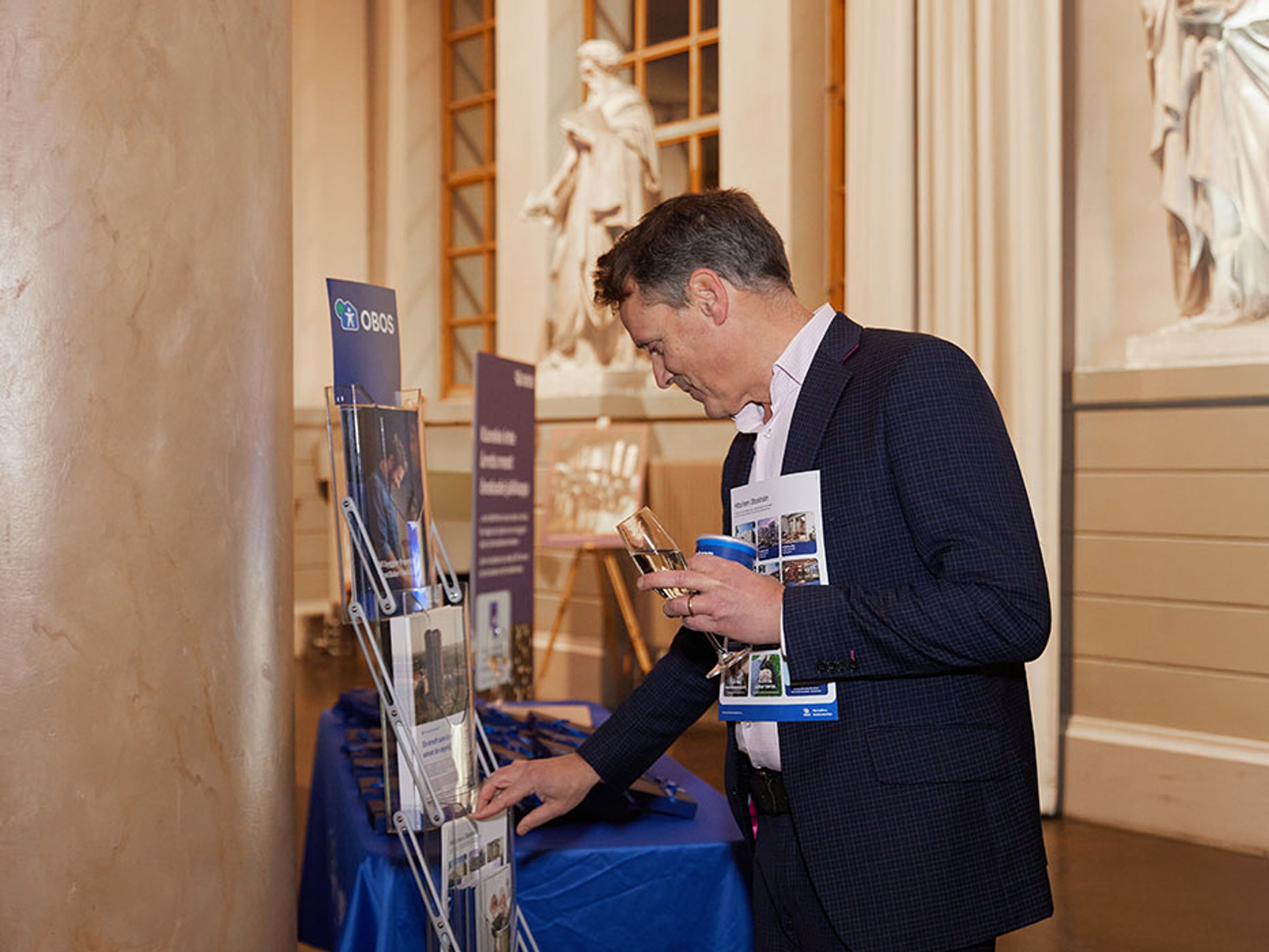 Medlem som plockar bostadsmaterial från broschyrställ