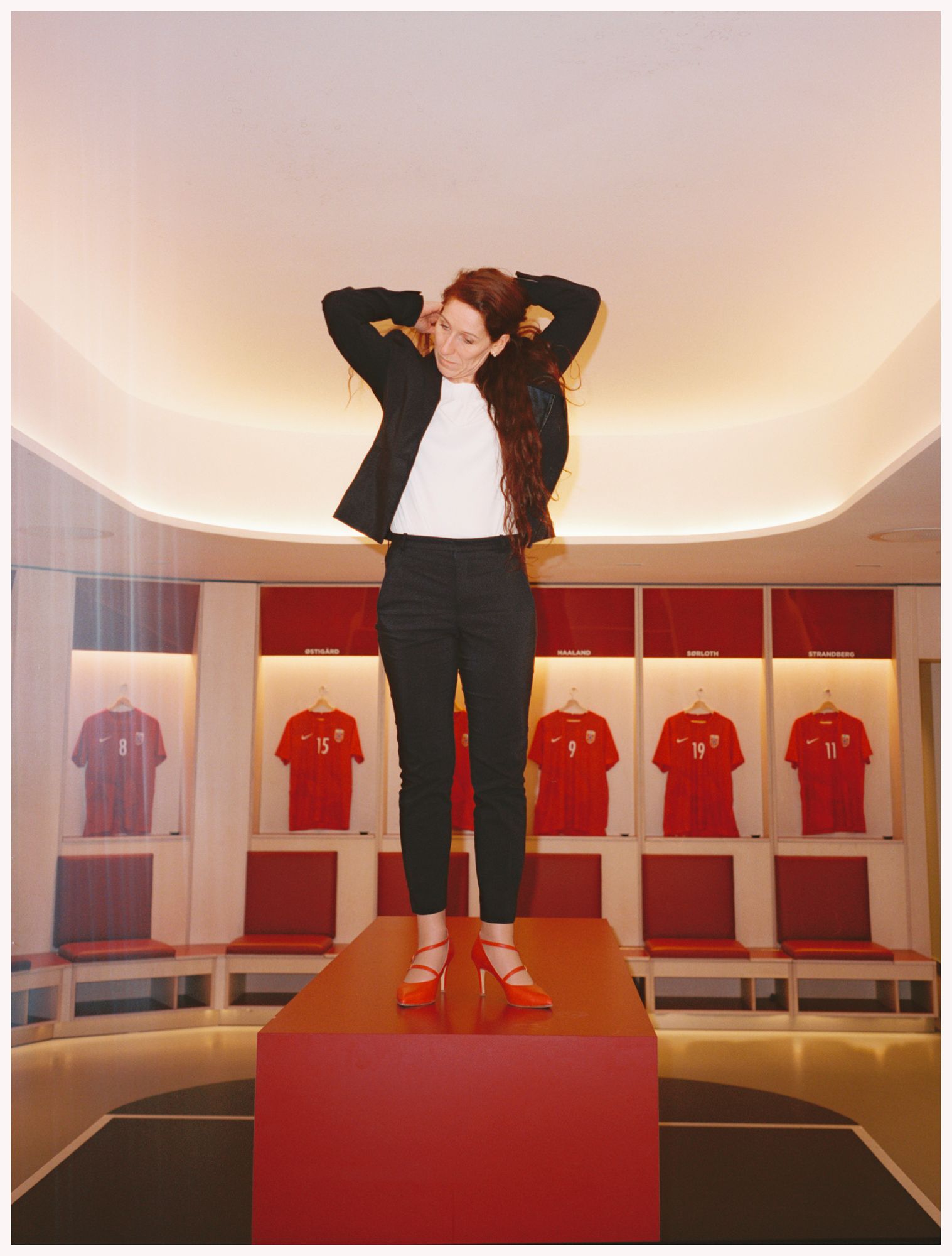 Lise Klaveness står på en boks midt i herregarderoben på Ullevaal Stadion.