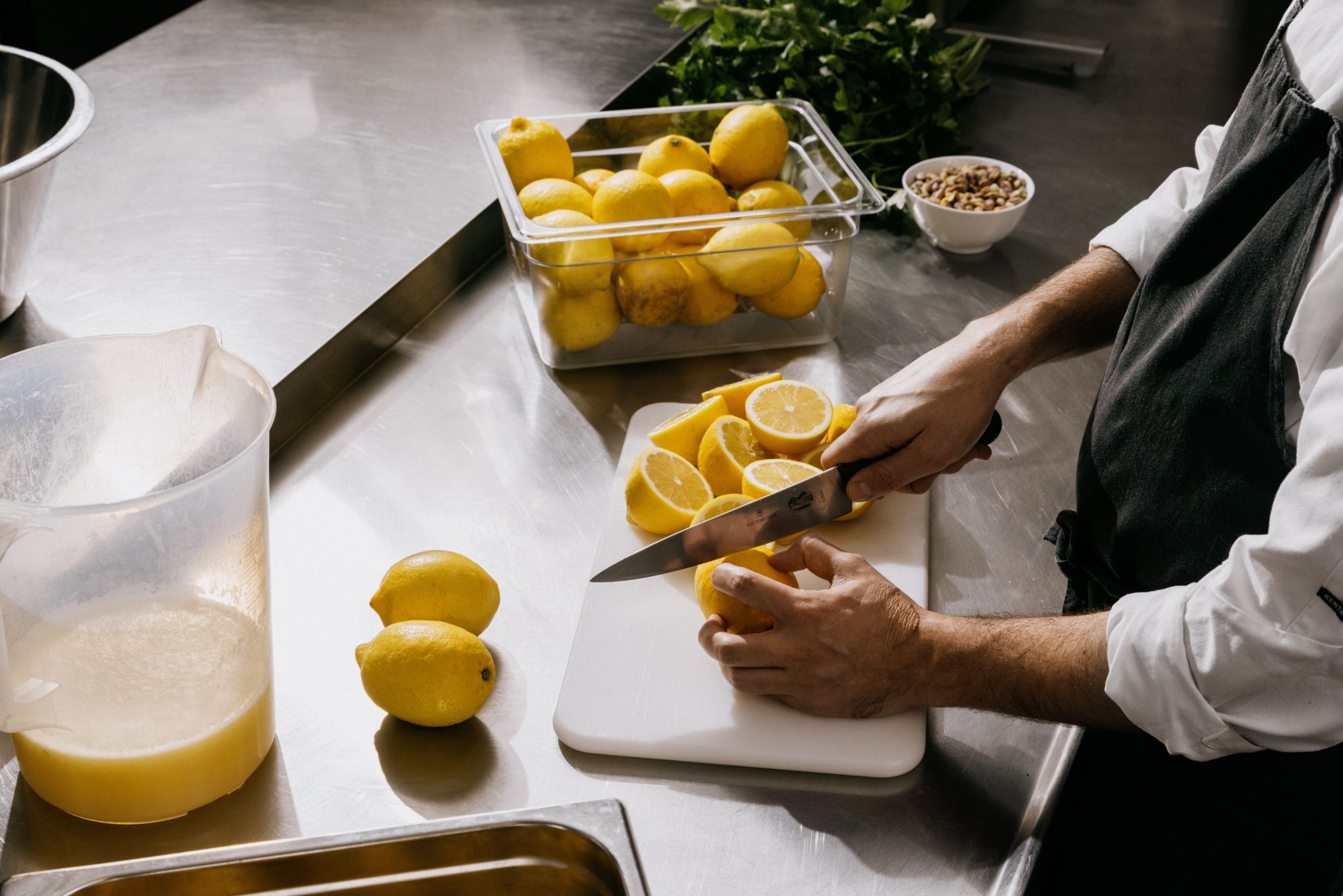 Breddebilde som viser hender som skjærer sitroner.