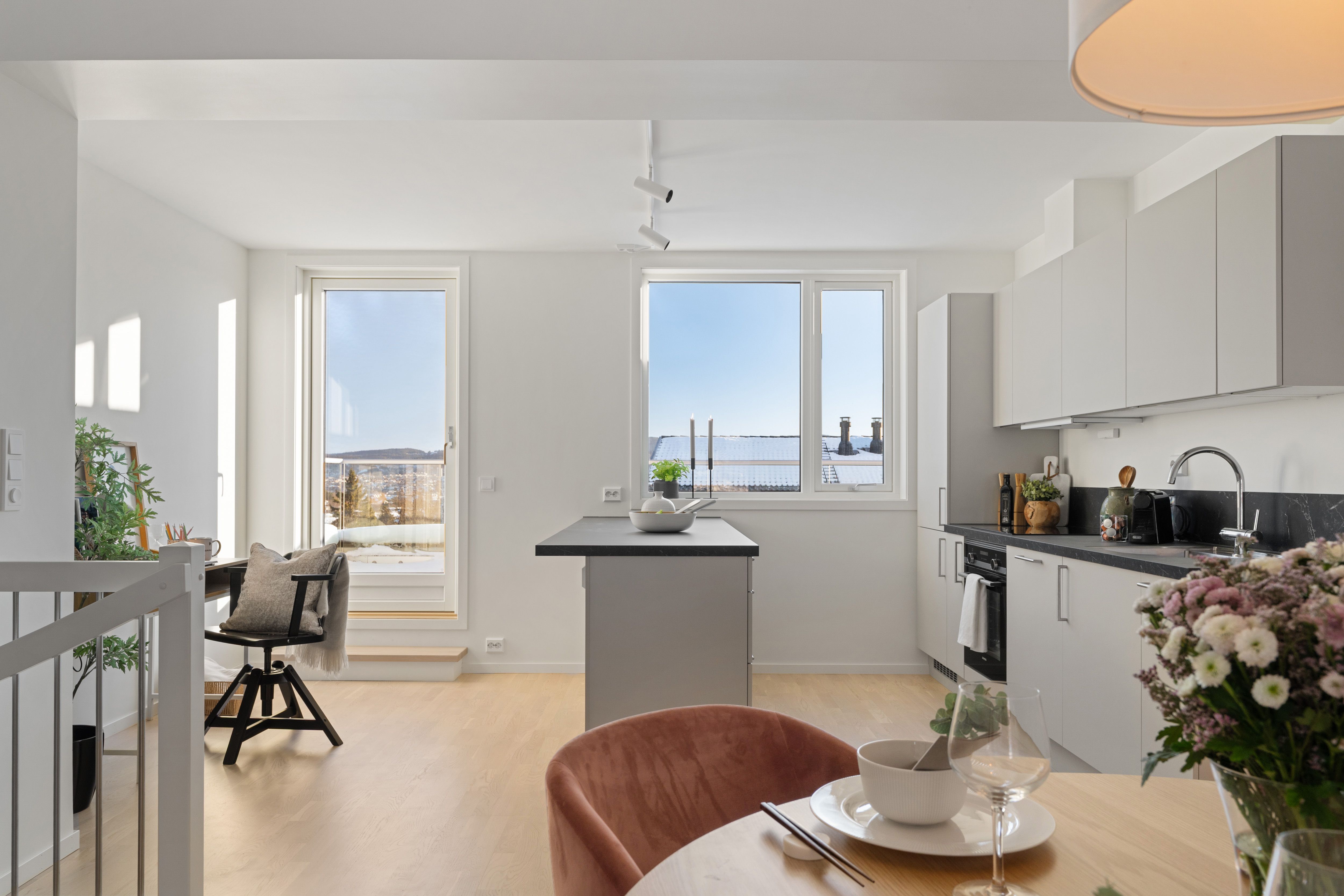 Bilde av kjøkken, stue og vinduer som slipper inn naturlig lys i rekkehus i Hovedhuset, i Nedre Stavsetvegen 46.