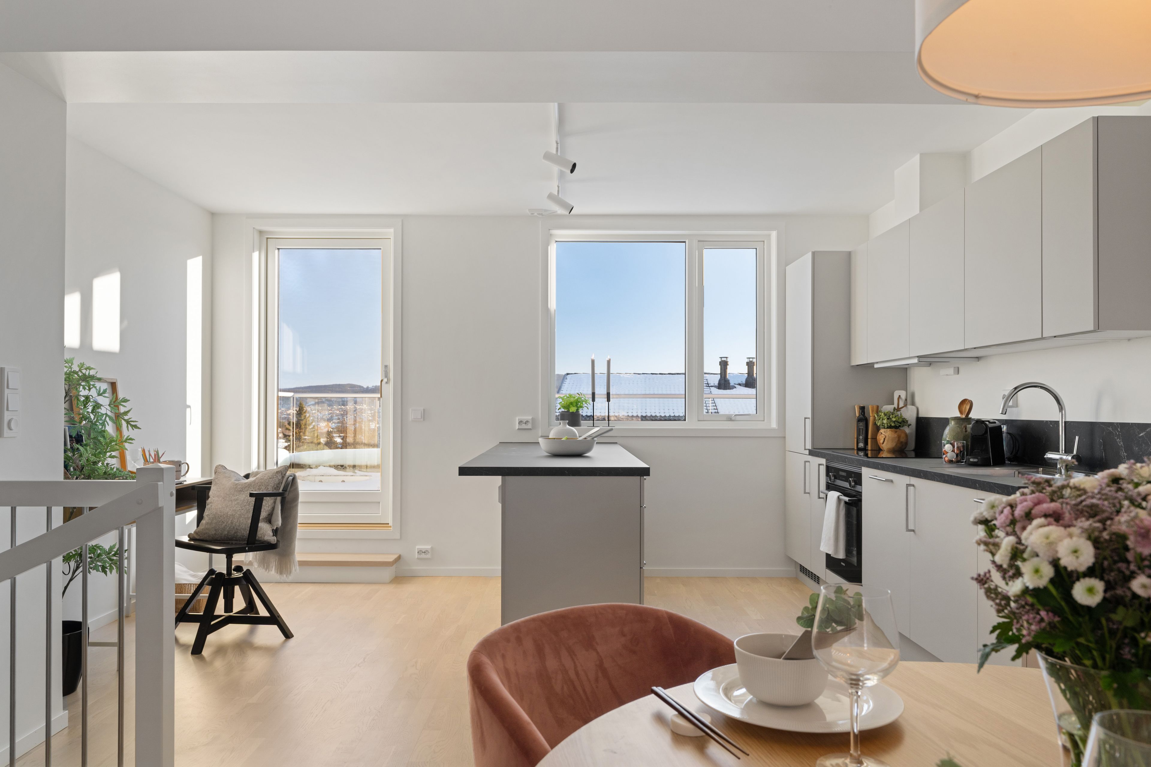 Bilde av kjøkken, stue og vinduer som slipper inn naturlig lys i rekkehus i Hovedhuset, i Nedre Stavsetvegen 46.