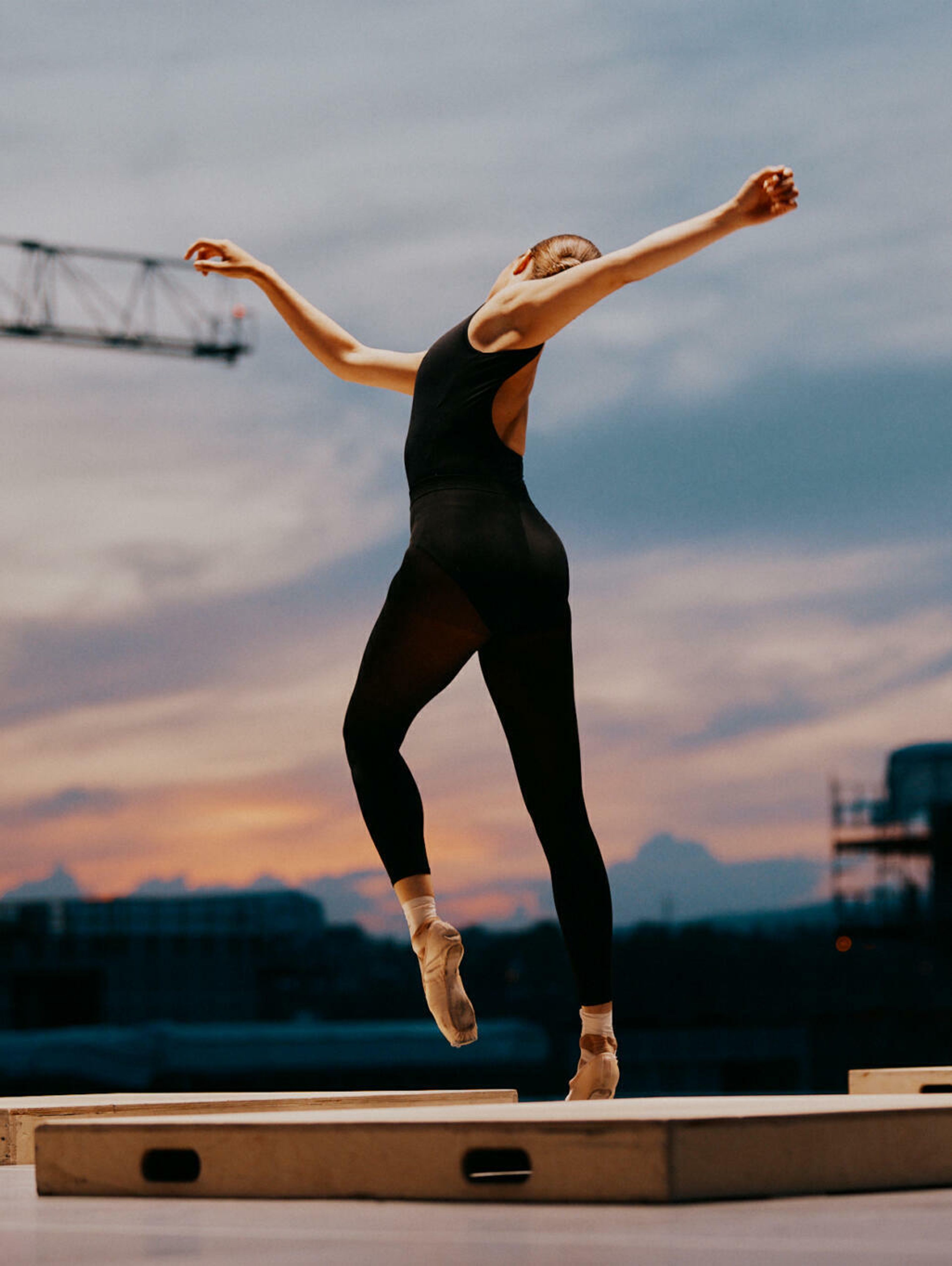 Ballettdanser strekker armene ut og spisser en tå.