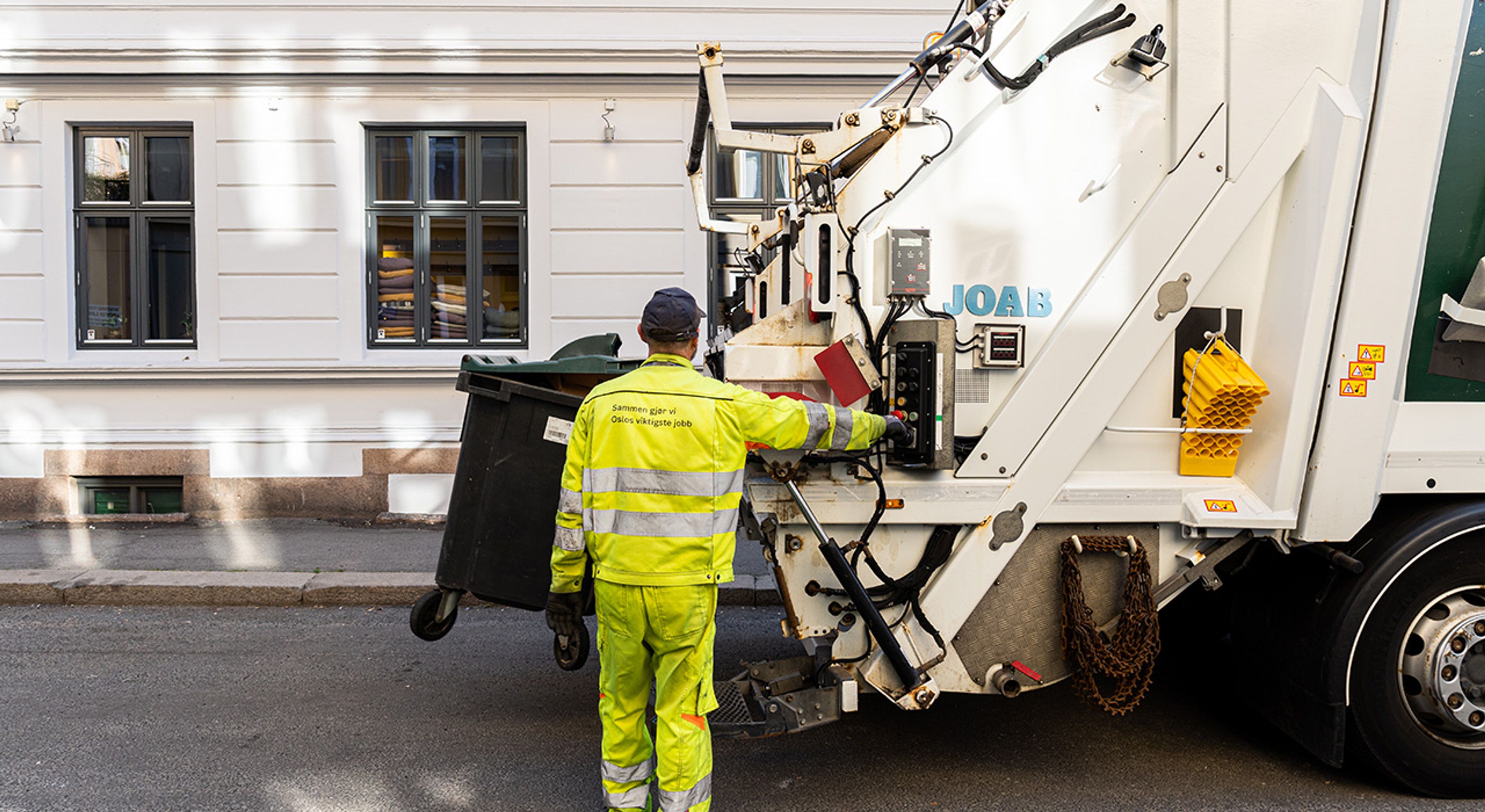 En renovasjonsmedarbeider henter avfall.