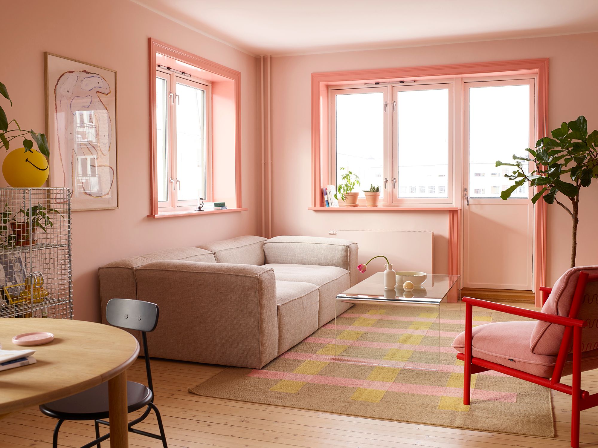 Rosa stue med rosa lister og ulike stuemøbler som beige sofa og rød/rosa stol.