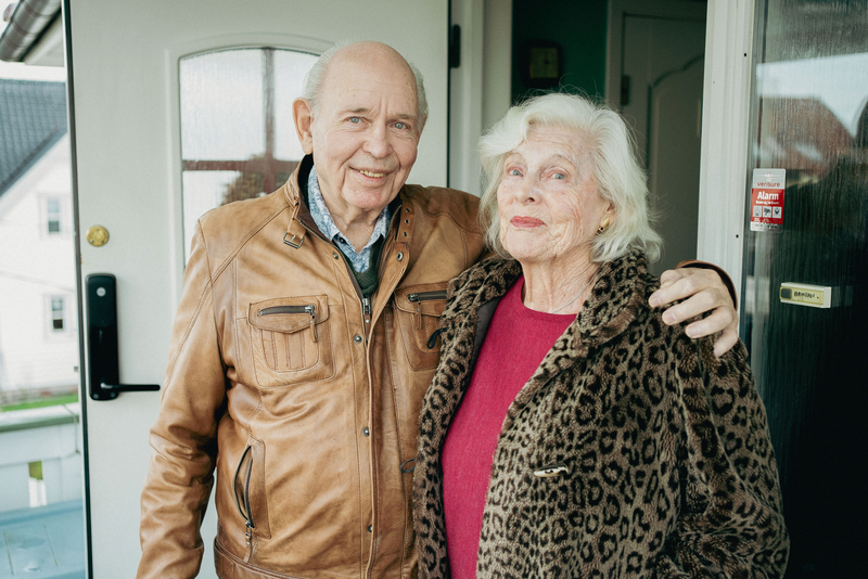Svein og Unni står utenfor ytterdøra og smiler mot kamera