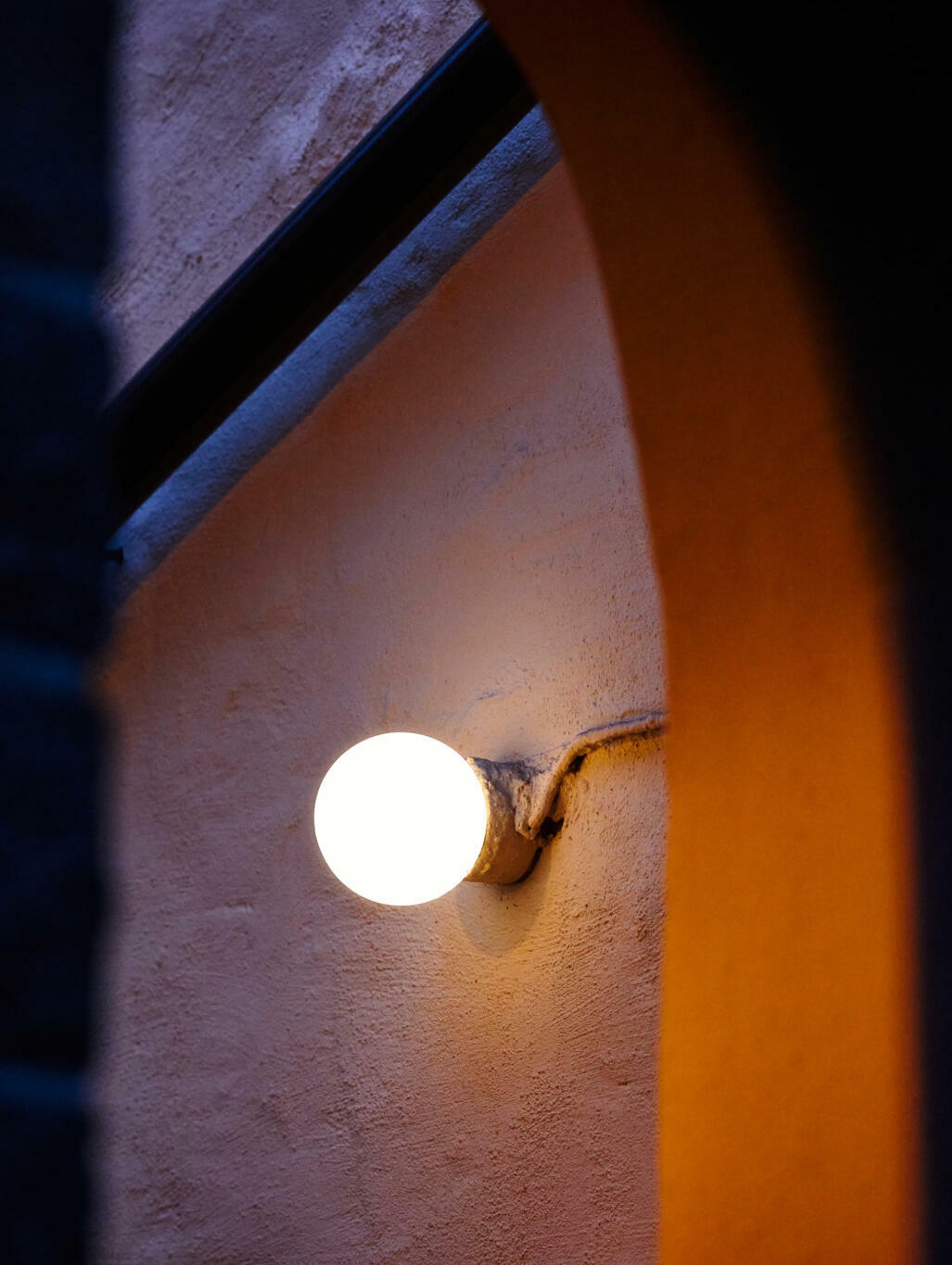 Bilde av en lampe som henger på en murvegg
