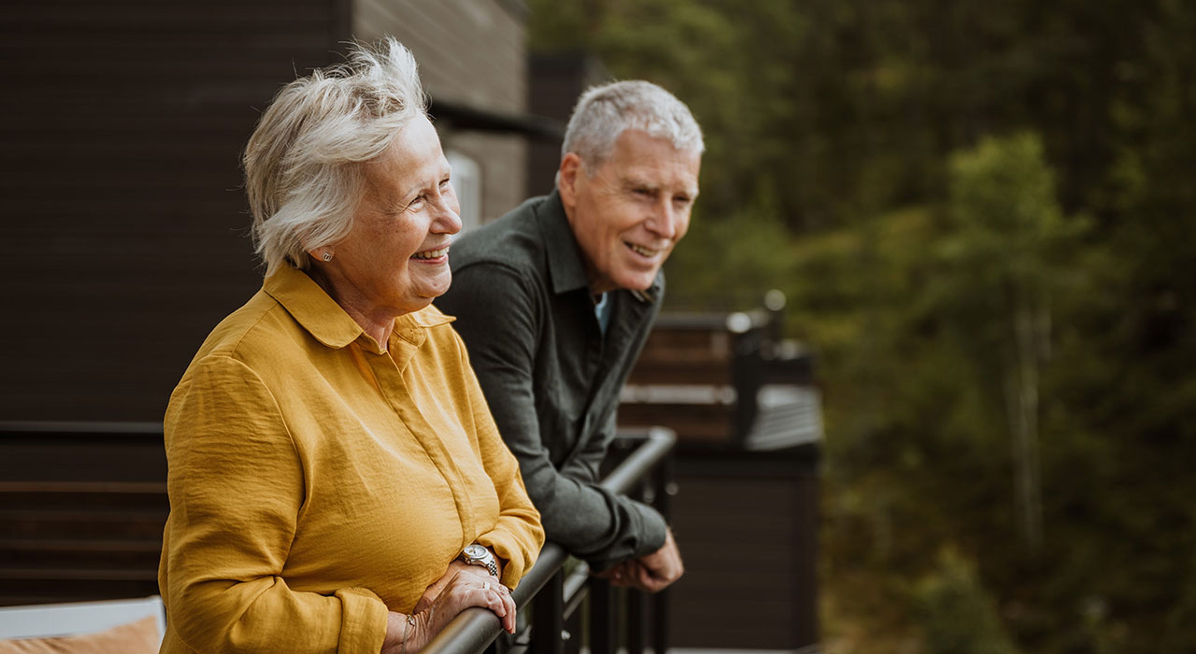 Eldre par ser på utsikten fra veranda i et OBOS Block Watne-hus