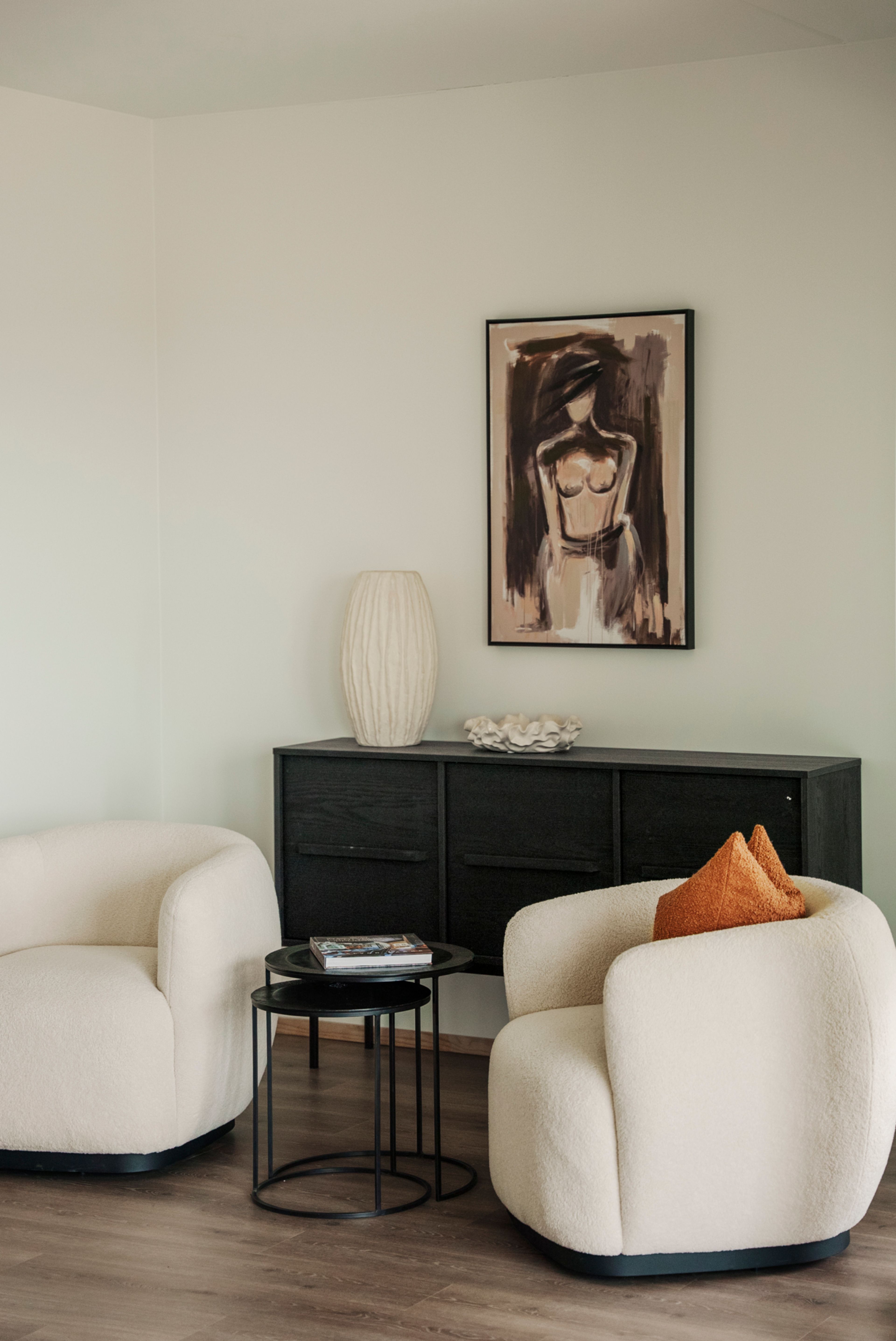 To lenestoler i hvitt med sort bord, skjenk og steingods.