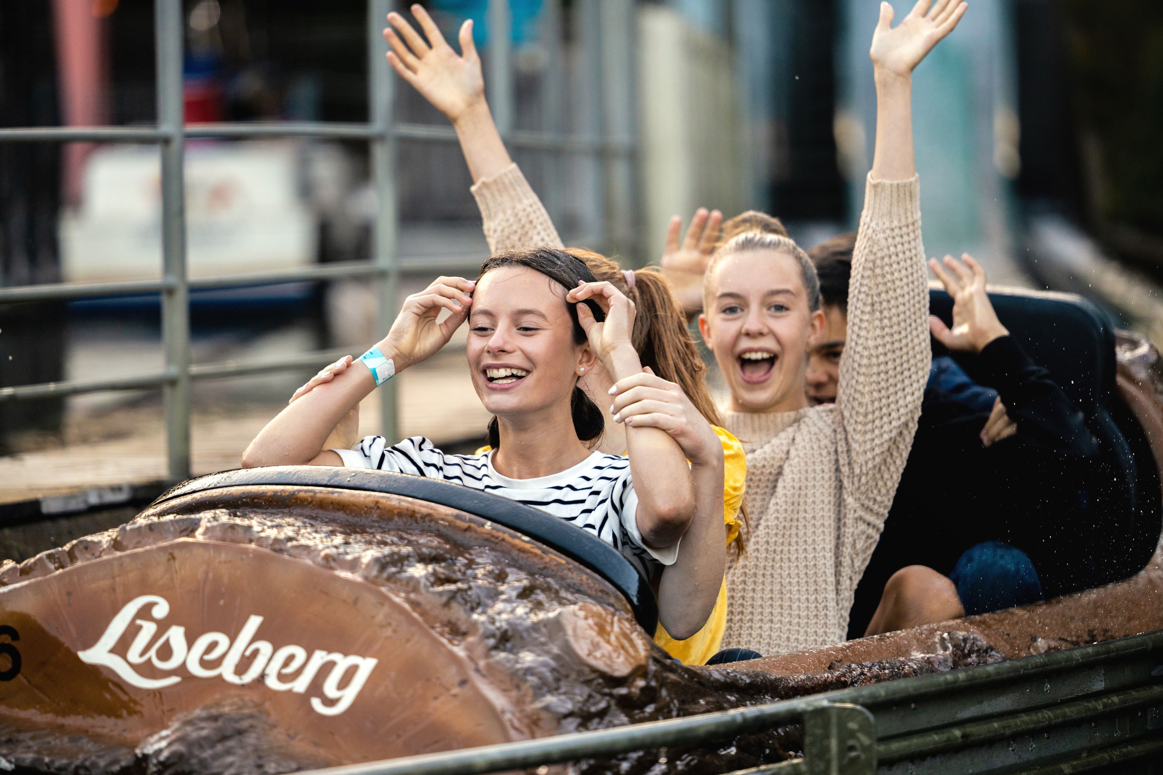 Liten jente som klemmer Liseberg maskoten i sommerdag