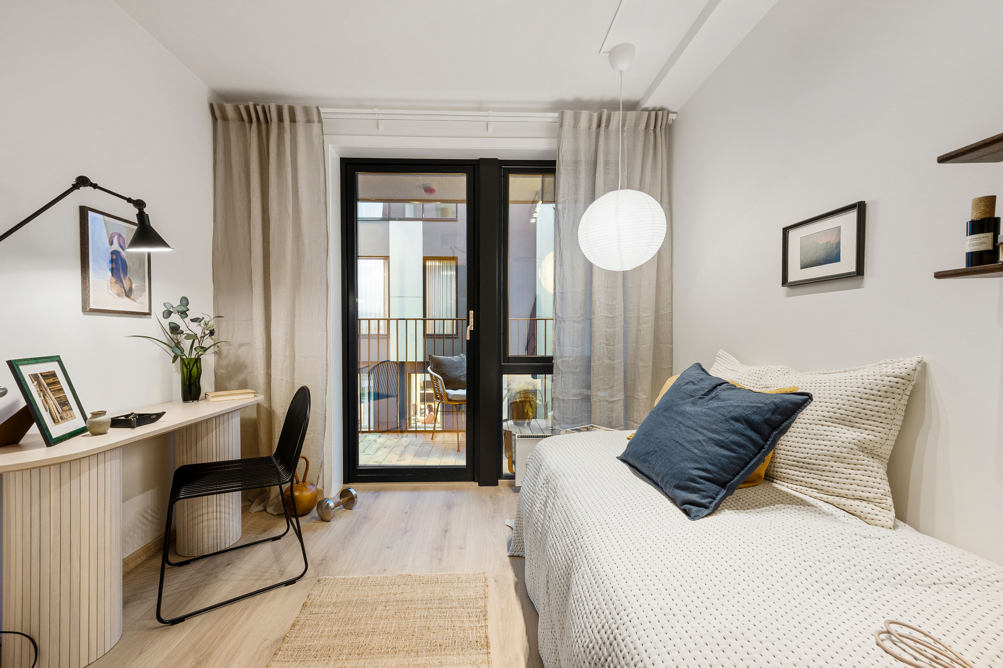 Soverom med seng, skrivepult og balkong