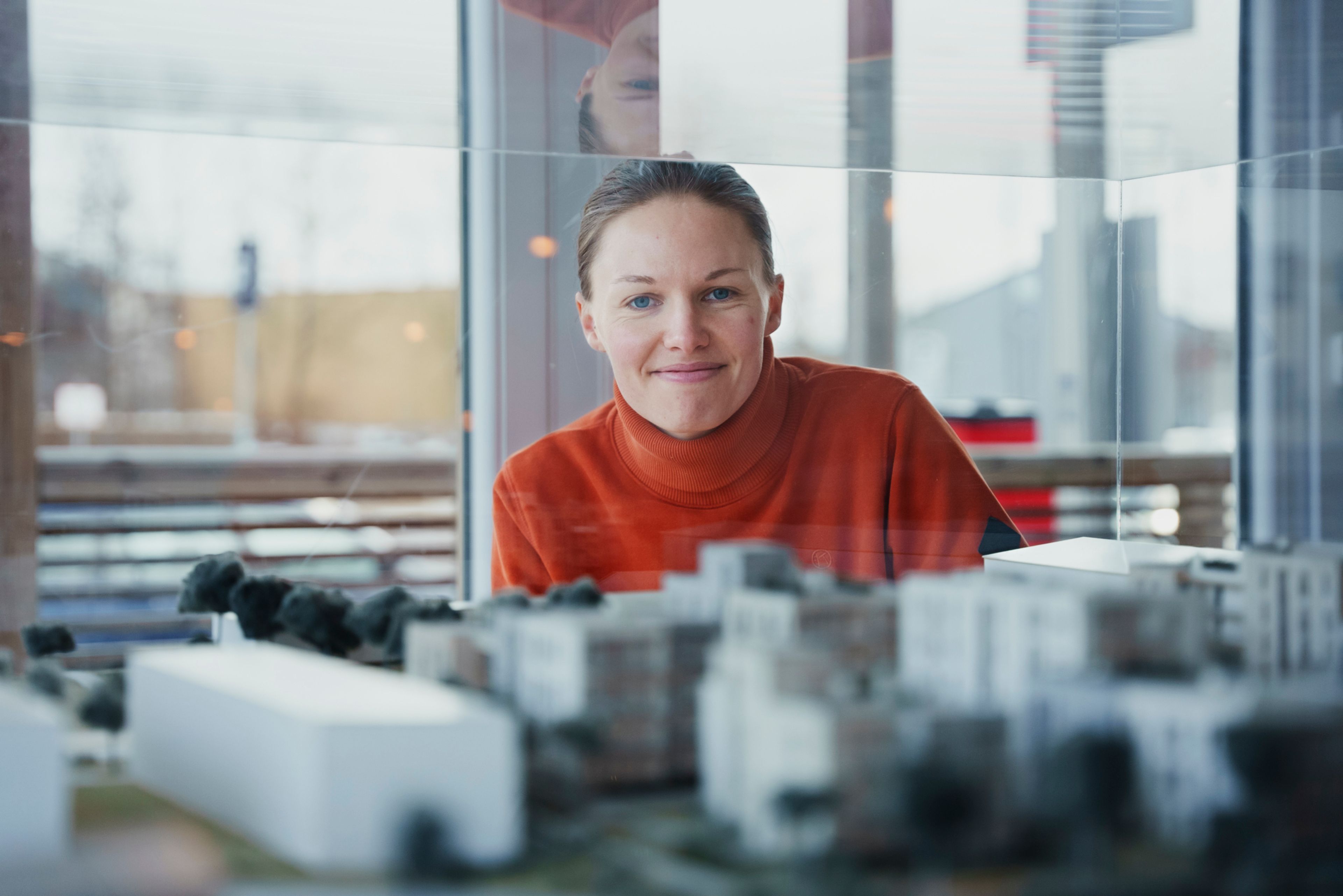 Martine ser på modellen av boligprosjektet Teieparken med et smil.