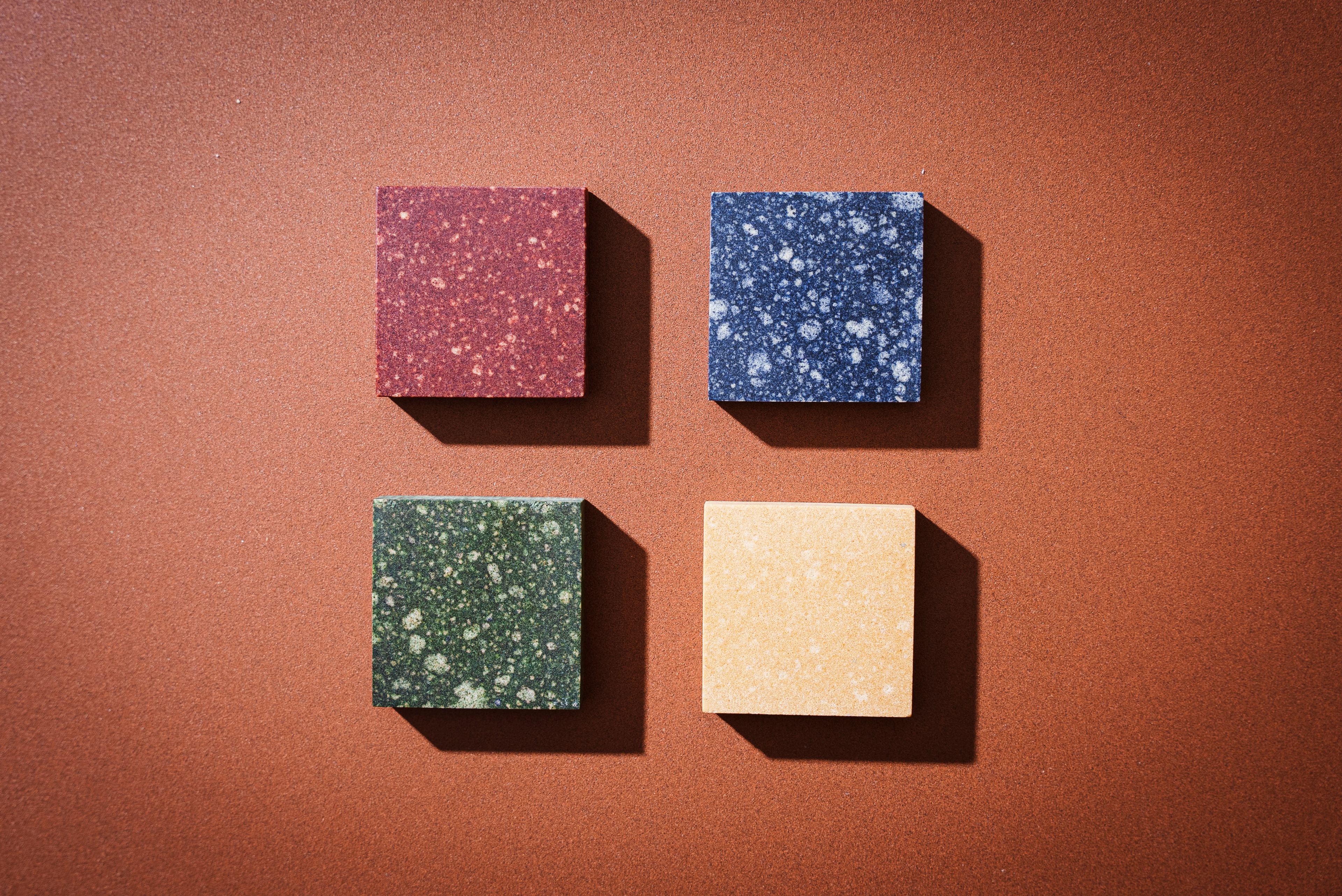 Fliser med veggprøver av ulike innovasjonsmaterialer som sopp, kaffe og fiskeskjell