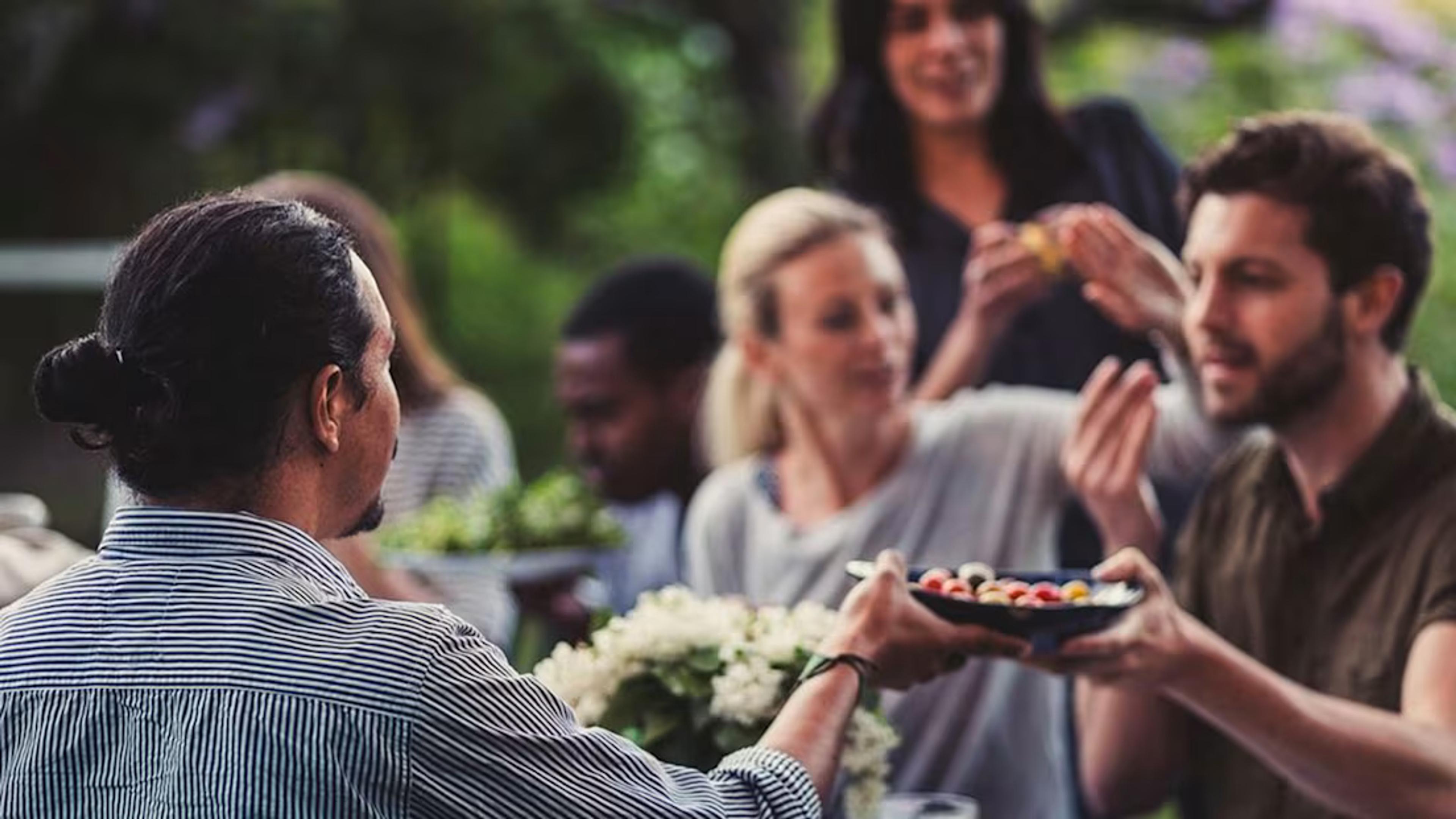 Människor äter ute i trädgården