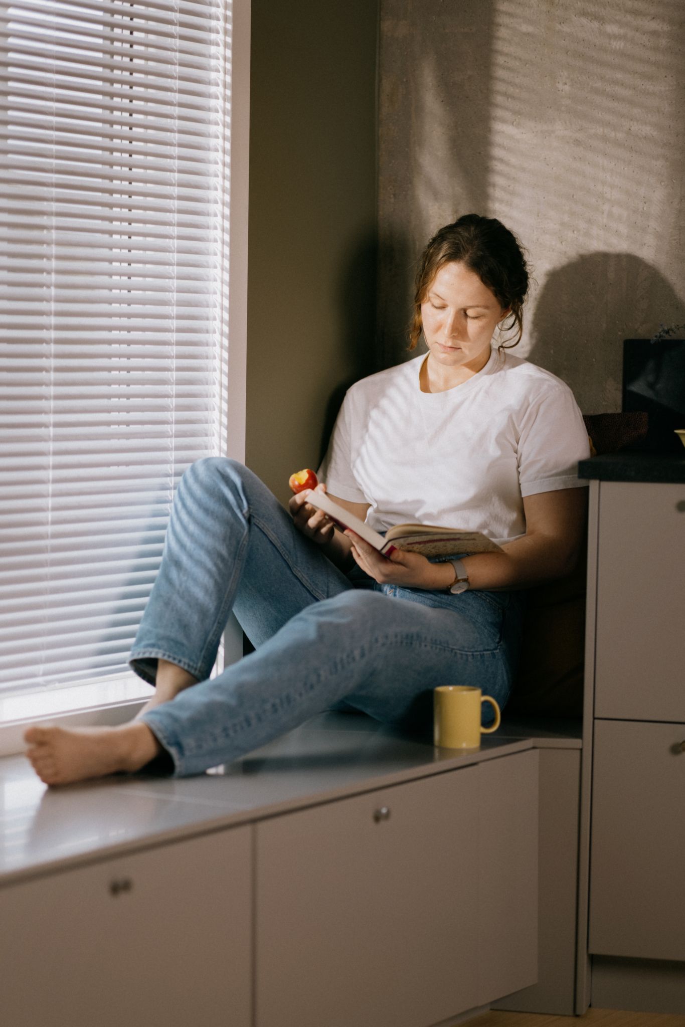 Foto av kvinne som leser en bok i en kjøkkenkrok i OBOS Living Lab