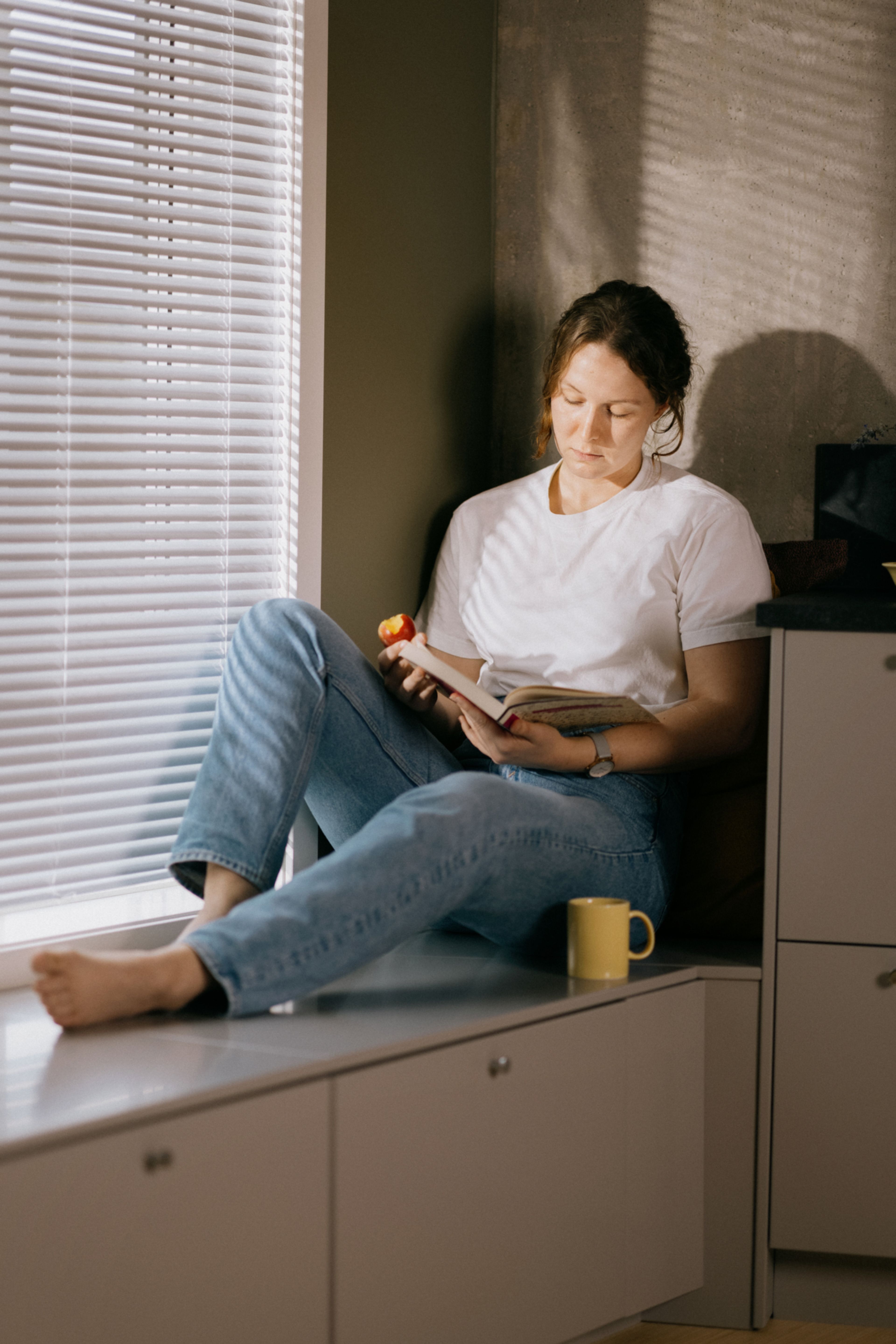 Foto av kvinne som leser en bok i en kjøkkenkrok i OBOS Living Lab