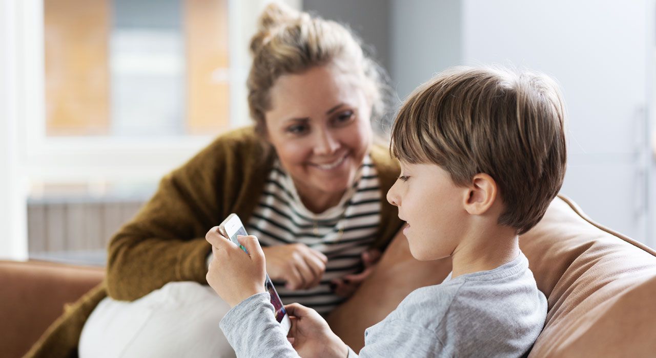Mamma och barn som kollar på mobilen