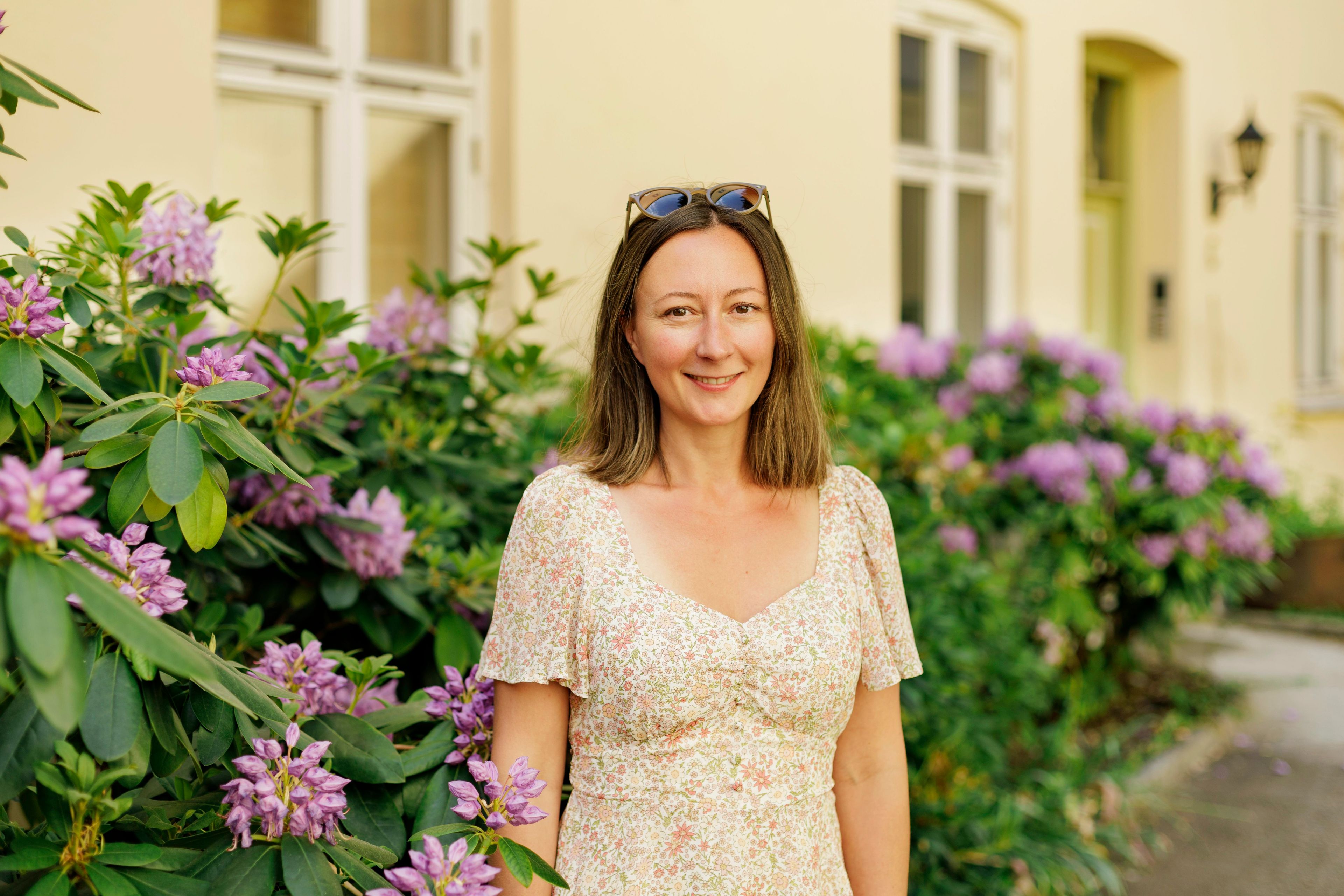 Styreleder Hanna Mari Hauans står i bakgården til borettslaget sitt.