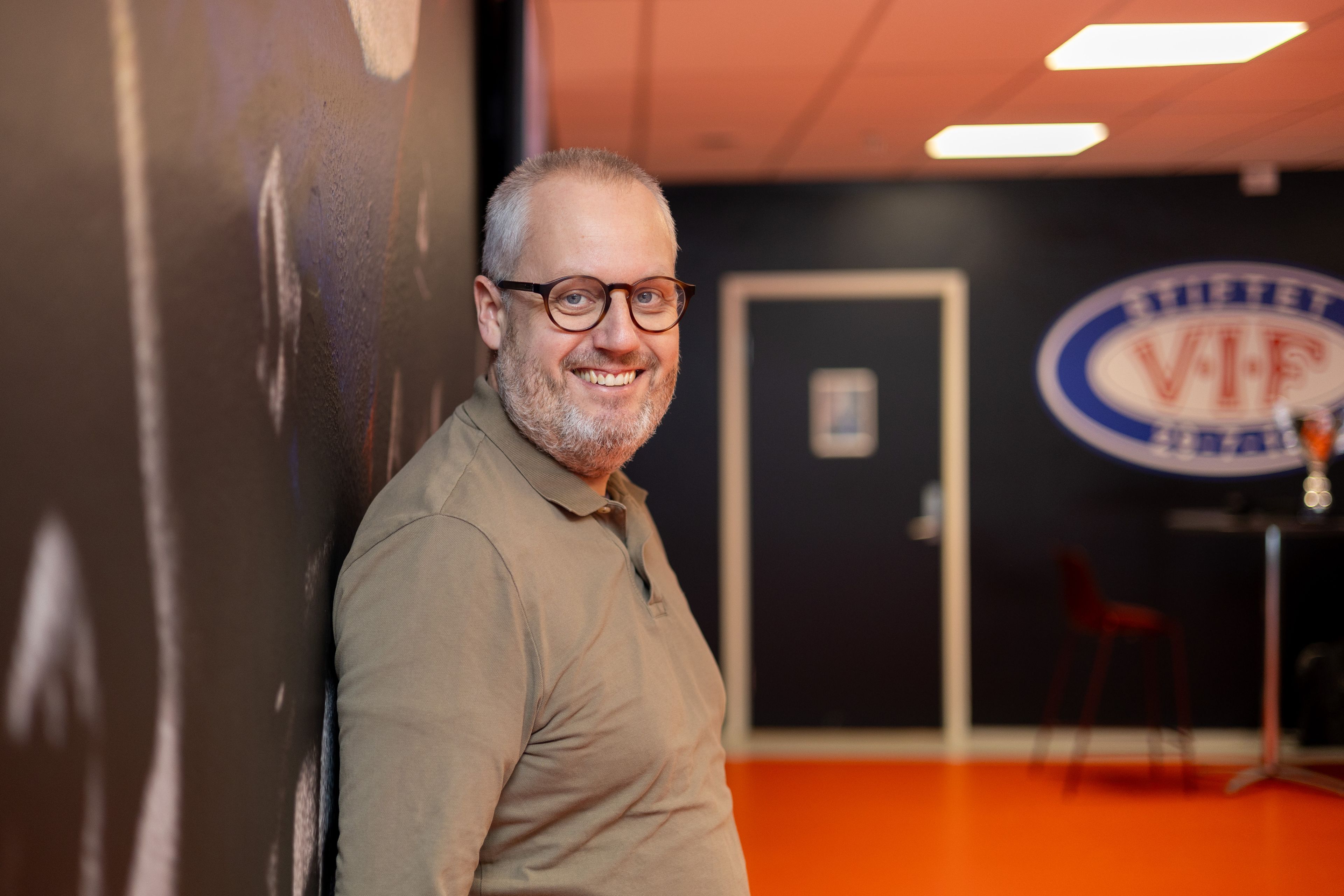 Mann med briller ser i kamera og smiler