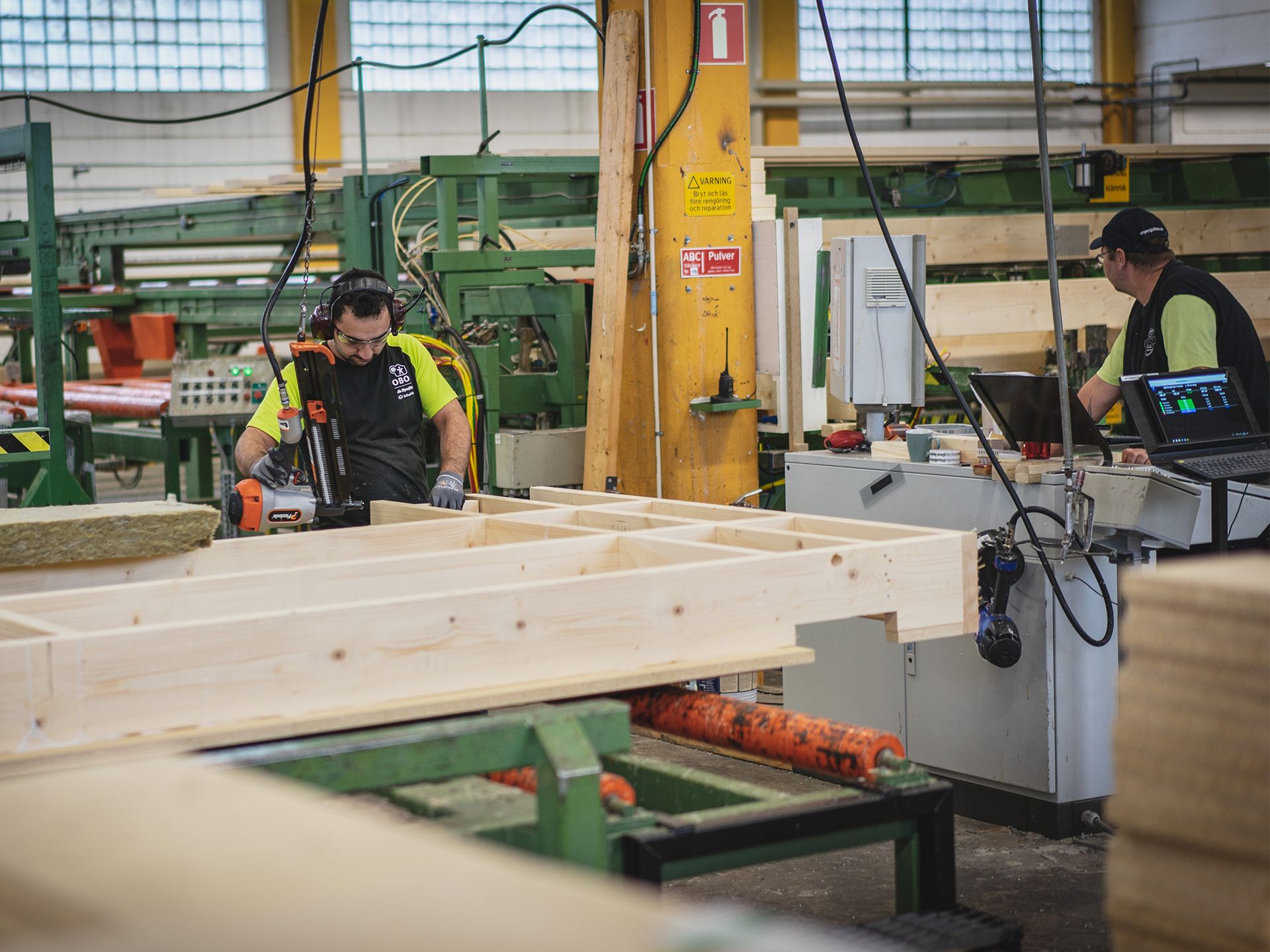 Flertalet obos arbetar som arbetar i en fabrik med obos trämoduler