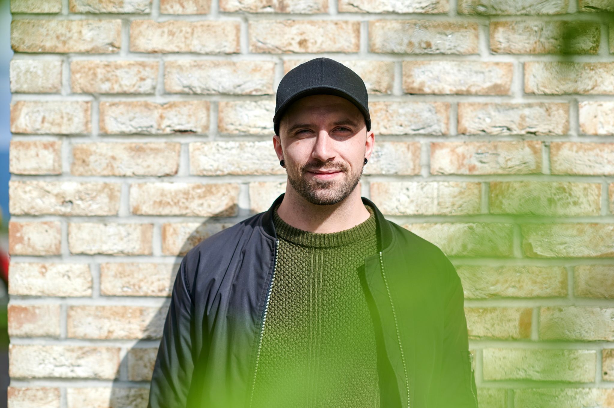 Foto av Kim-Leander foran en murvegg