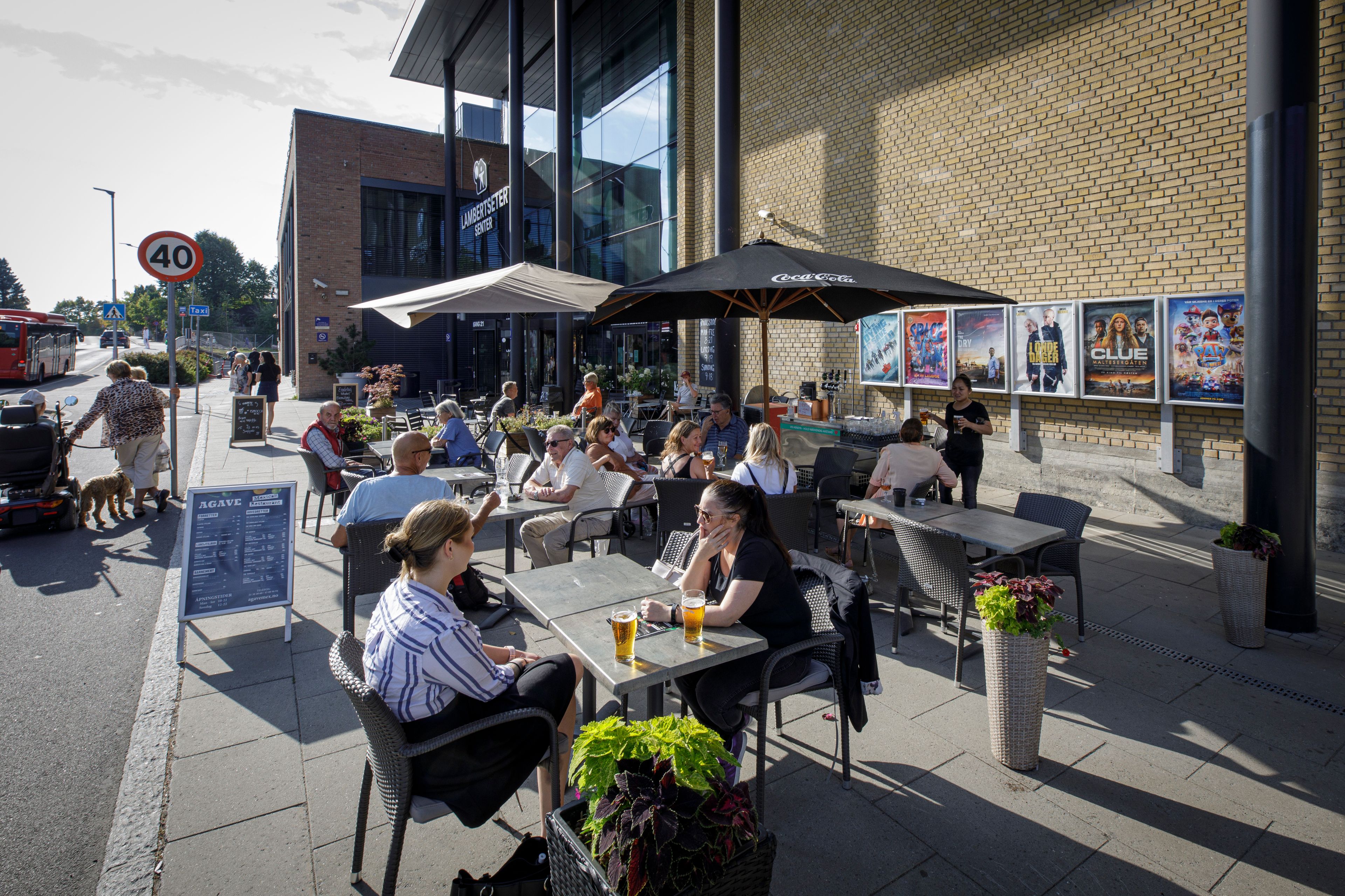 Folk sitter ute ved en av uteserveringene på Lambertseter Senter.