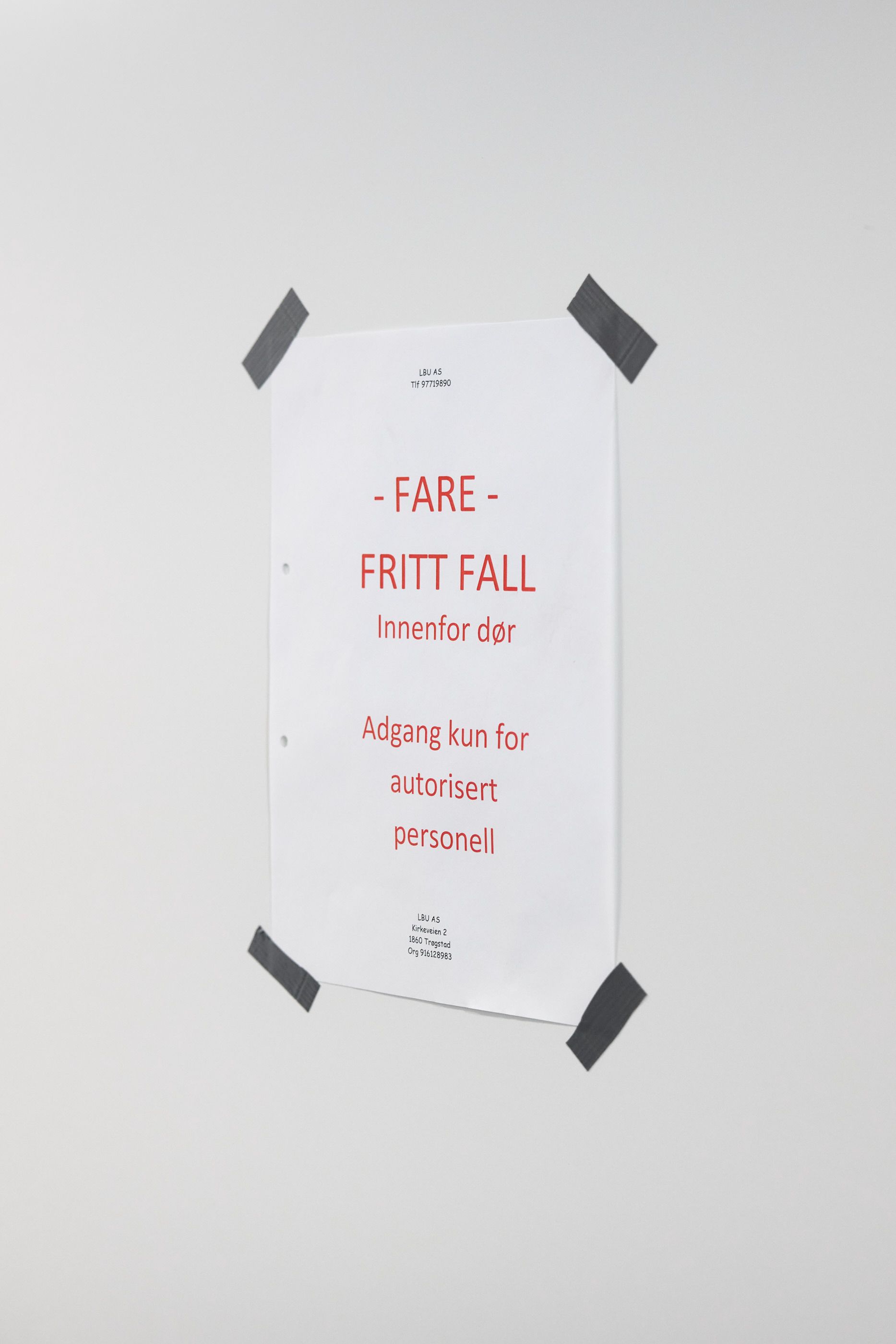 Skriftlig advarsel på et A4-ark med teksten "Fare fritt fall"